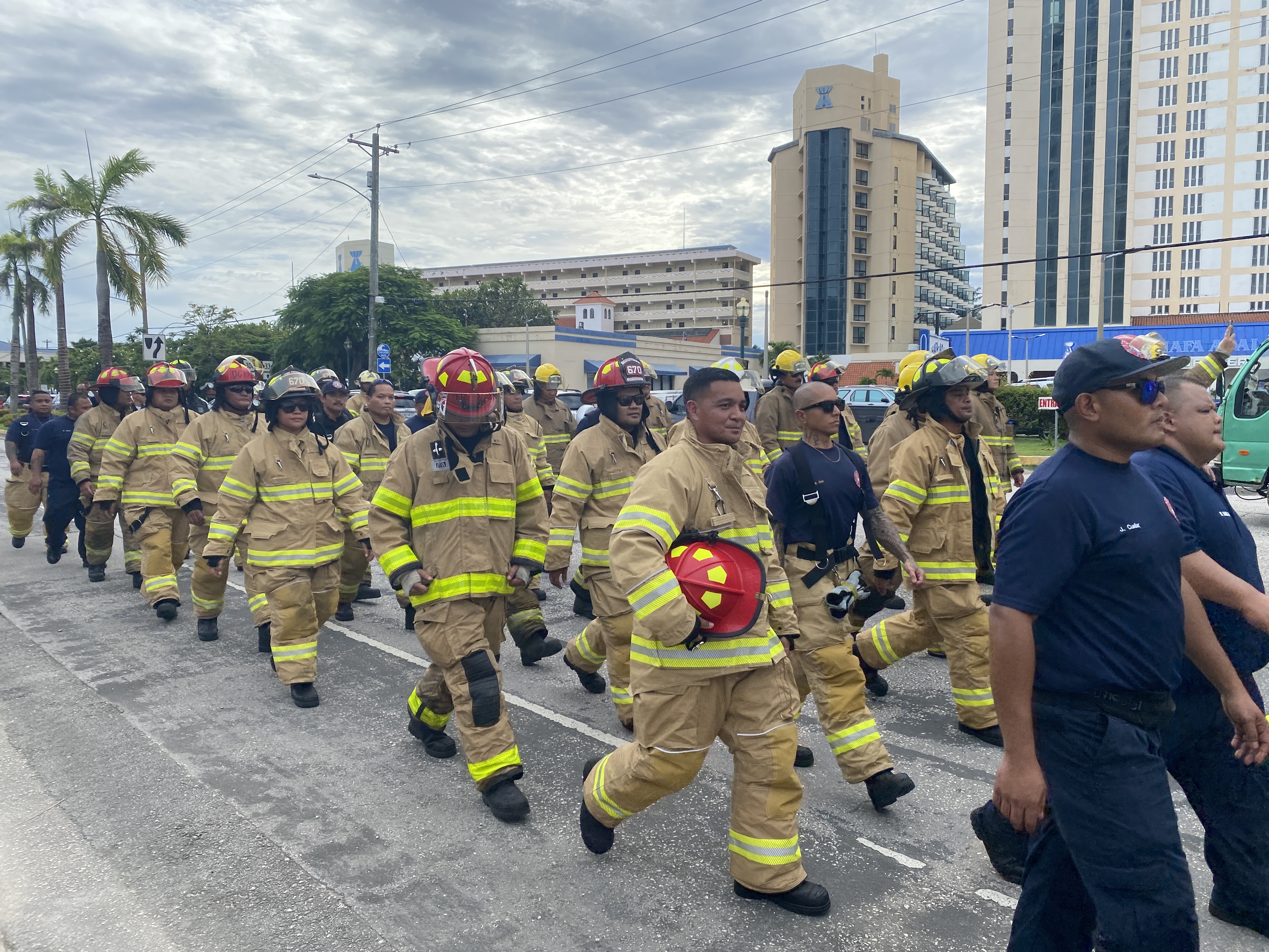 Firefighters walk down Beach Road on the way to American Memorial Park.