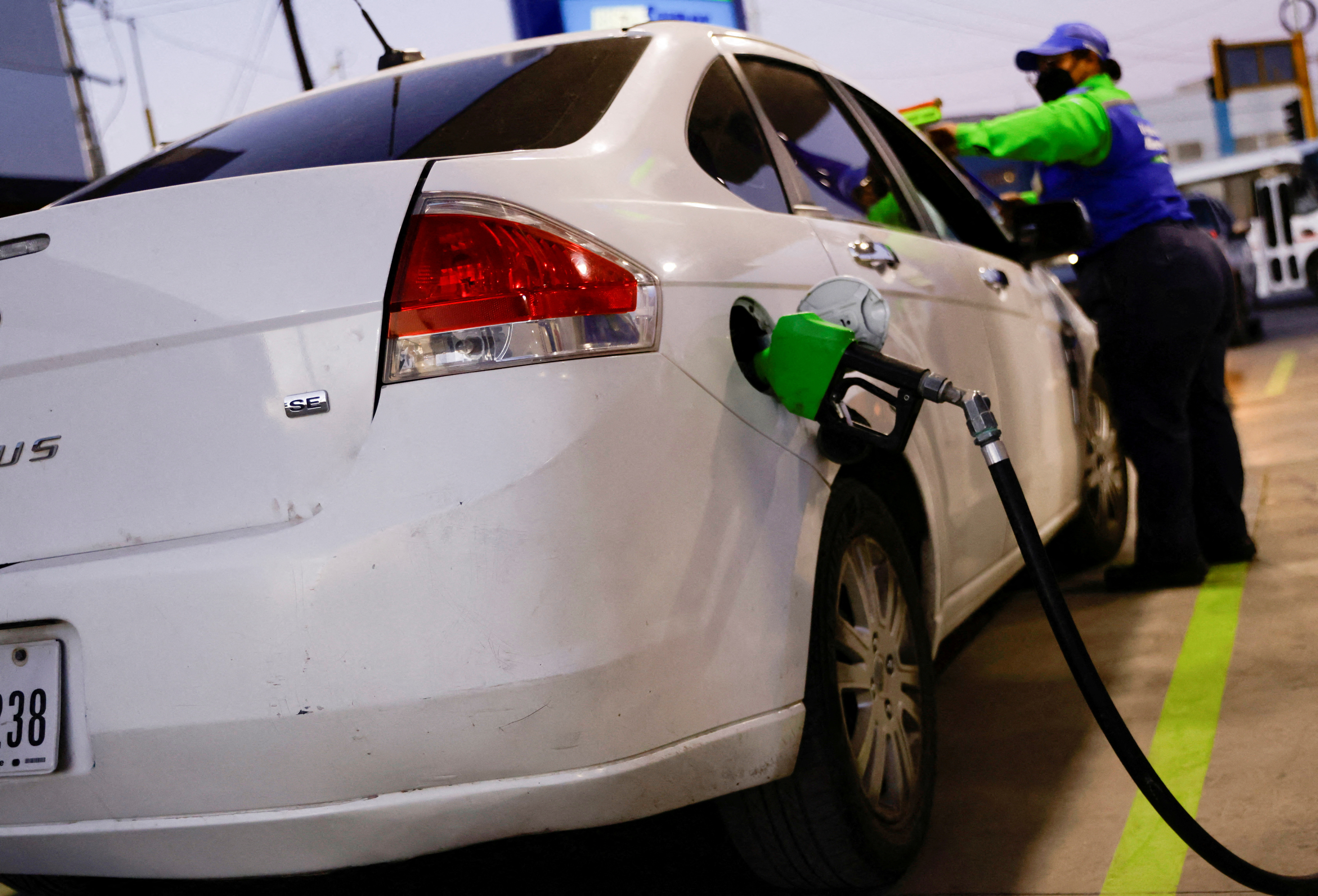 A worker fills a car belonging to a Texas resident, with gasoline at a gas station, in Ciudad Juarez, Mexico March 14, 2022. 
