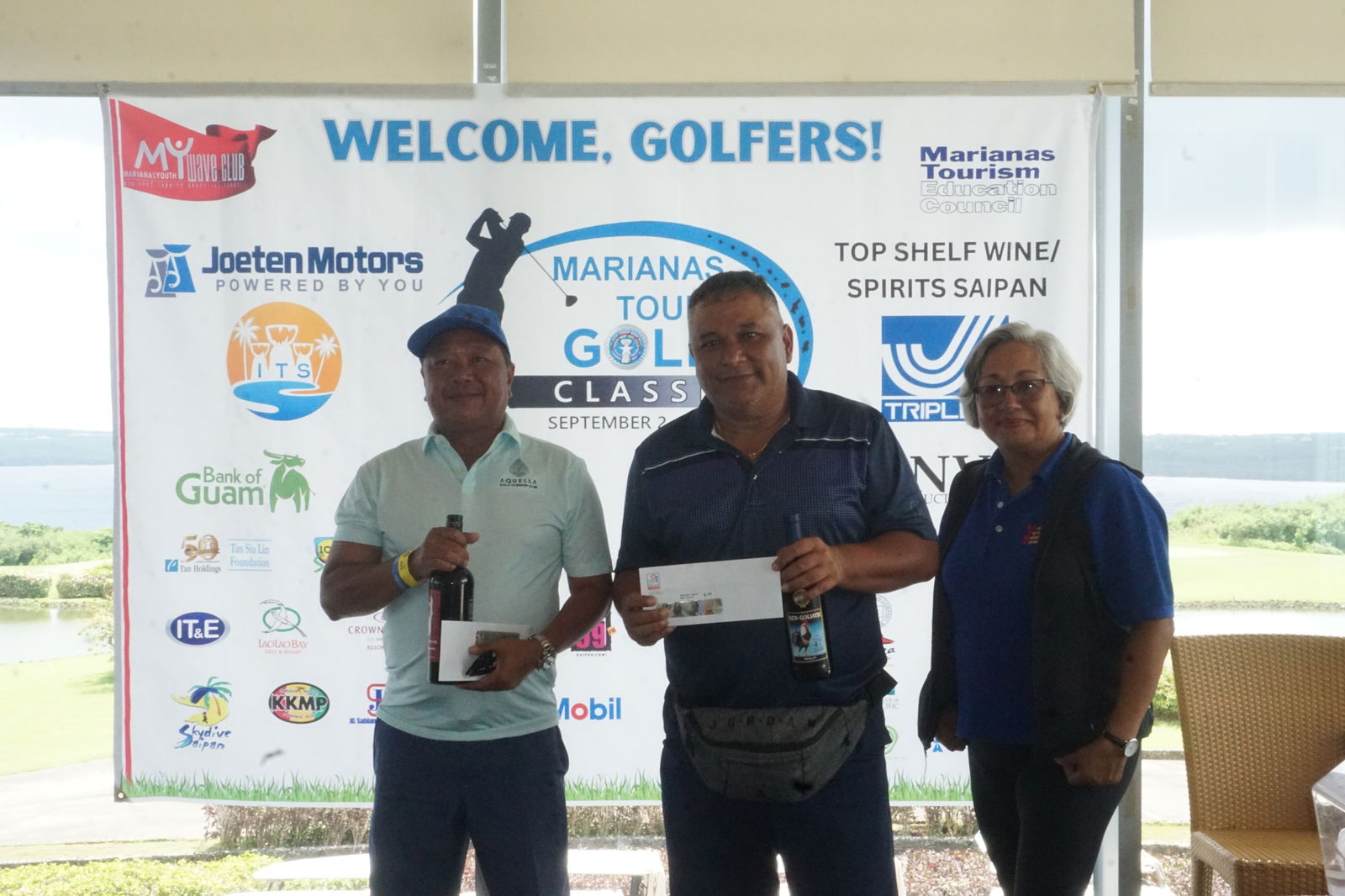 Senior flight top winner Freddie Cataluna and Frank Sablan, who finished third, pose for a photo with Marianas Tourism Education Council Chair Vicky Benavente during the awards ceremony of the 2023 Marianas Tourism Golf Classic on Saturday at the LaoLao Bay Golf & Resort west course. 