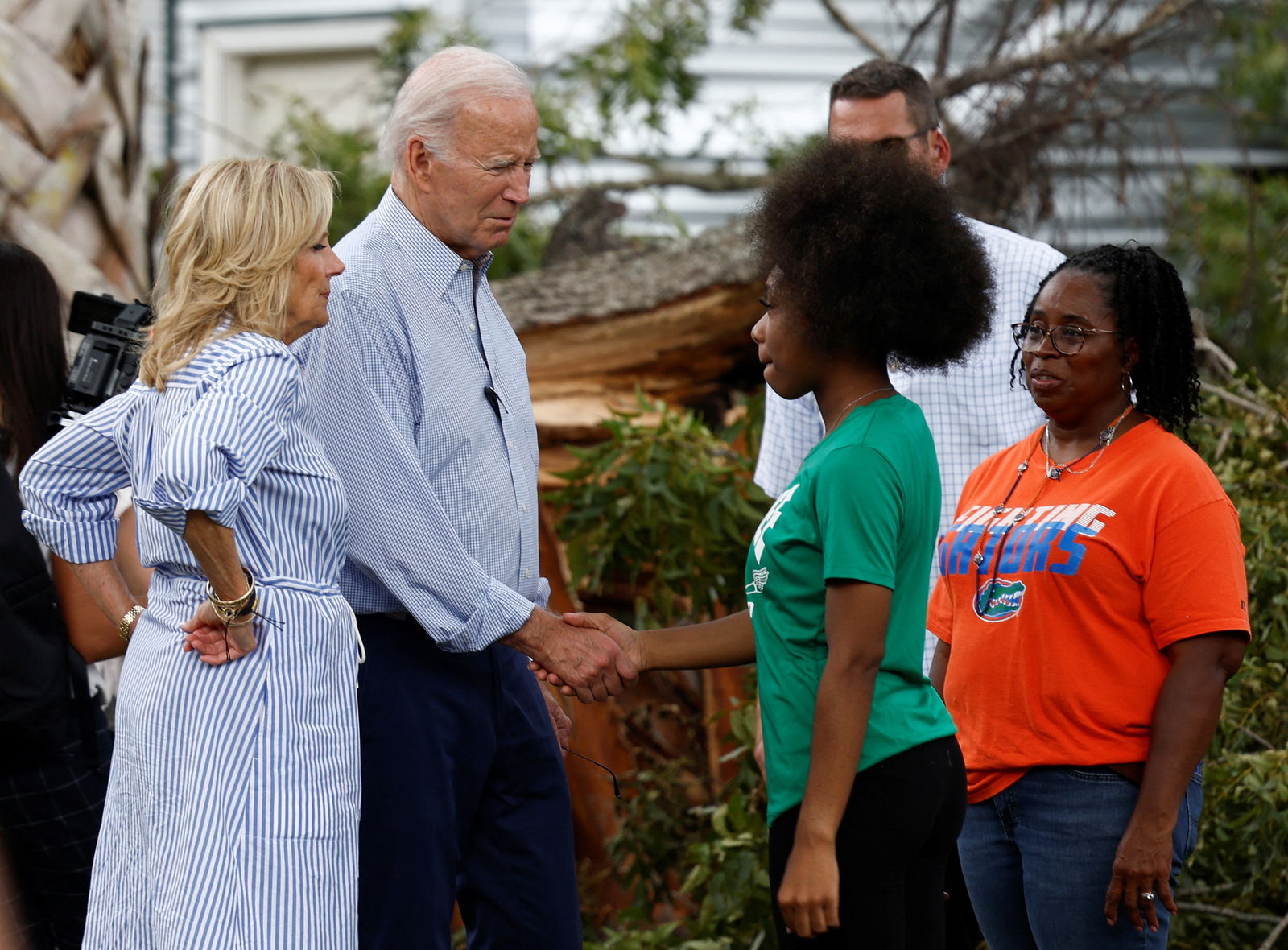 U.S. President Joe Biden shakes hands with a woman, next to first lady Jill Biden as they tour Hurricane Idalia storm destruction in a neighborhood of Live Oak, Florida, U.S., September 2, 2023. REUTERS/Evelyn Hockstein