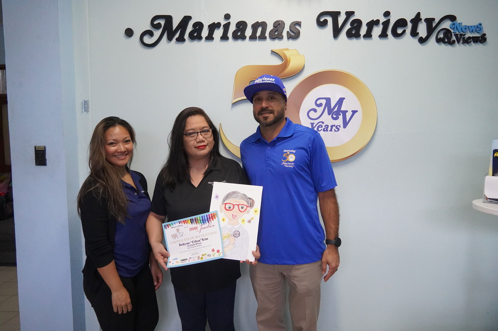 First grade teacher Cathy Merencilla showcases a detailed portrait of herself drawn by one of her students, Dohyun "Ethan" Kim, who found he won 1st place while he was off-island.