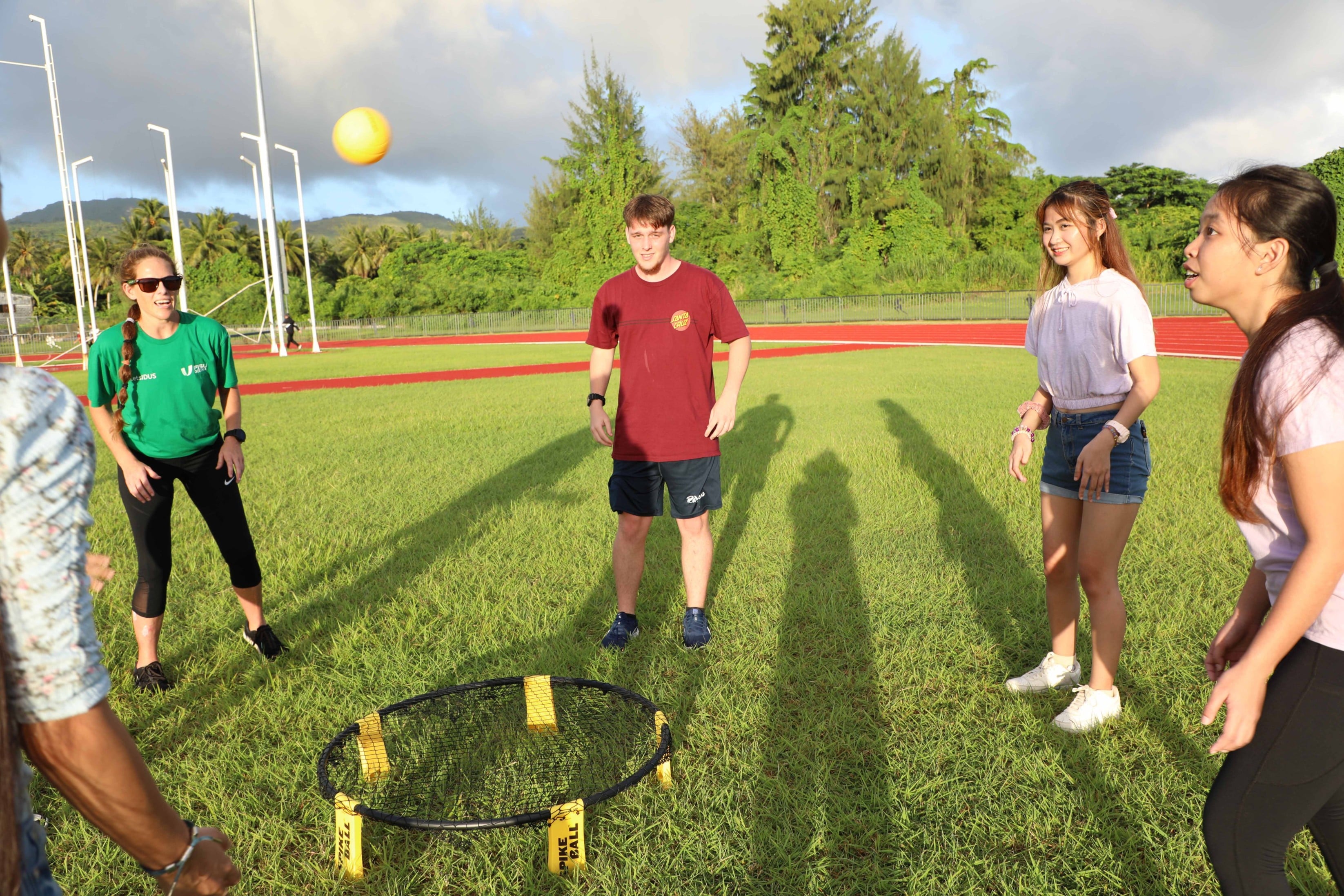 Merrick McDonald, Angel Reyes, and Bea Caungal learn spikeball with fellow NMC students and community members.