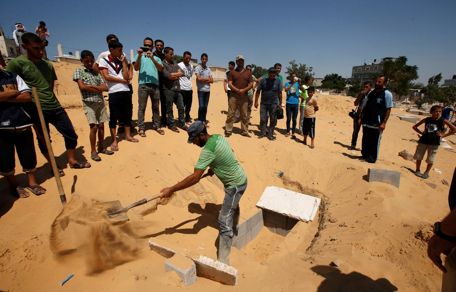 A Palestinian prepares a grave to bury the bodies of the wife of Hamas's military leader, Mohammed Deif, and his infant son Ali, whom medics said were killed in an Israeli air strike, at a cemetery in Beit Lahiya in the northern Gaza Strip August 20, 2014.