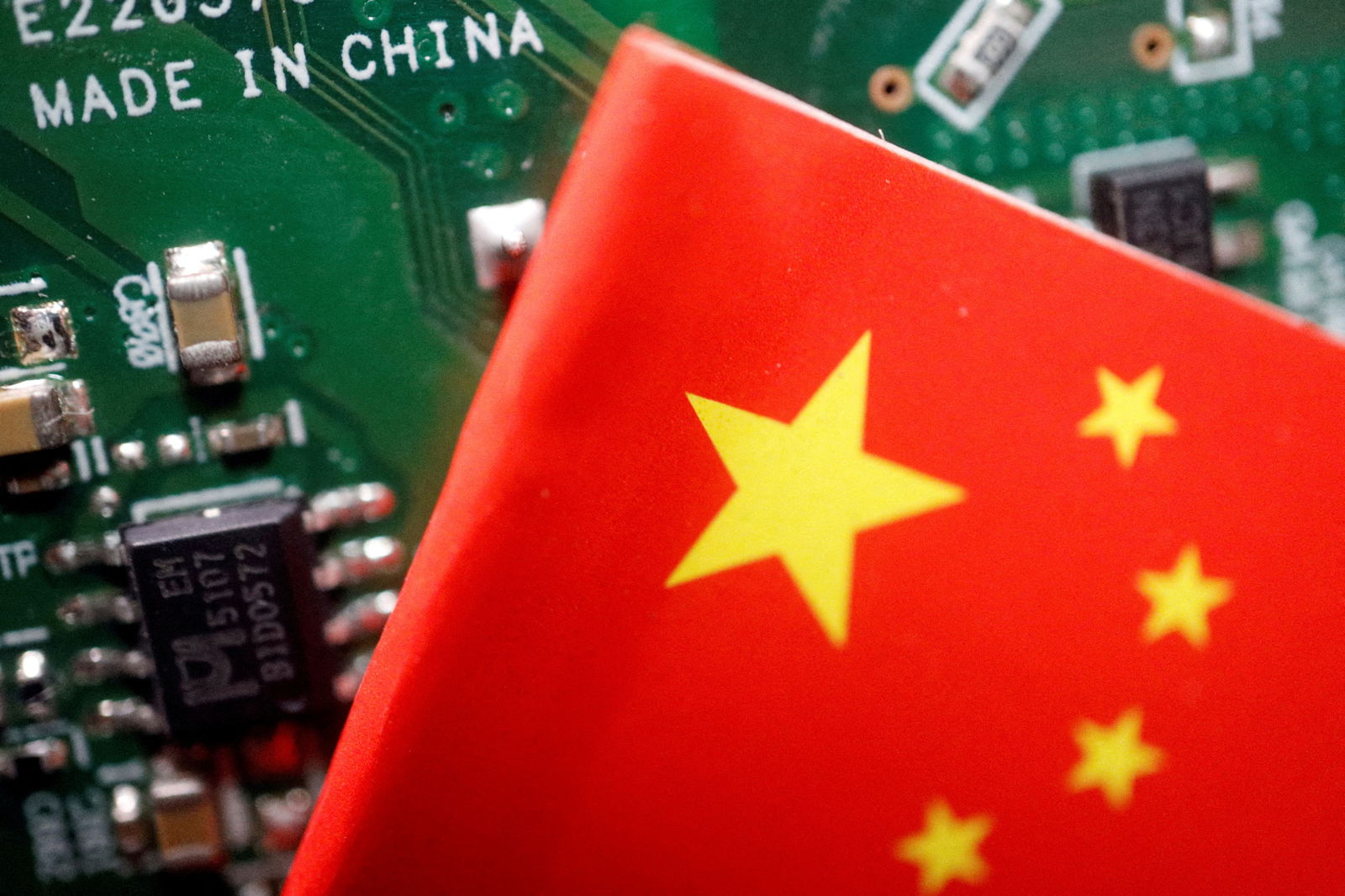 A Chinese flag is displayed next to a "Made in China" sign seen on a printed circuit board with semiconductor chips, in this illustration picture taken Feb. 17, 2023.
