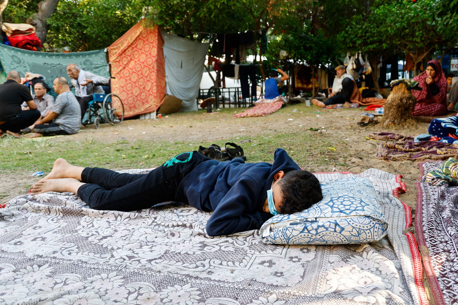 A boy rests as Palestinians who fled their homes due to Israeli strikes shelter at al-Shifa hospital in Gaza City, October 12, 2023. REUTERS/Mohammed Salem