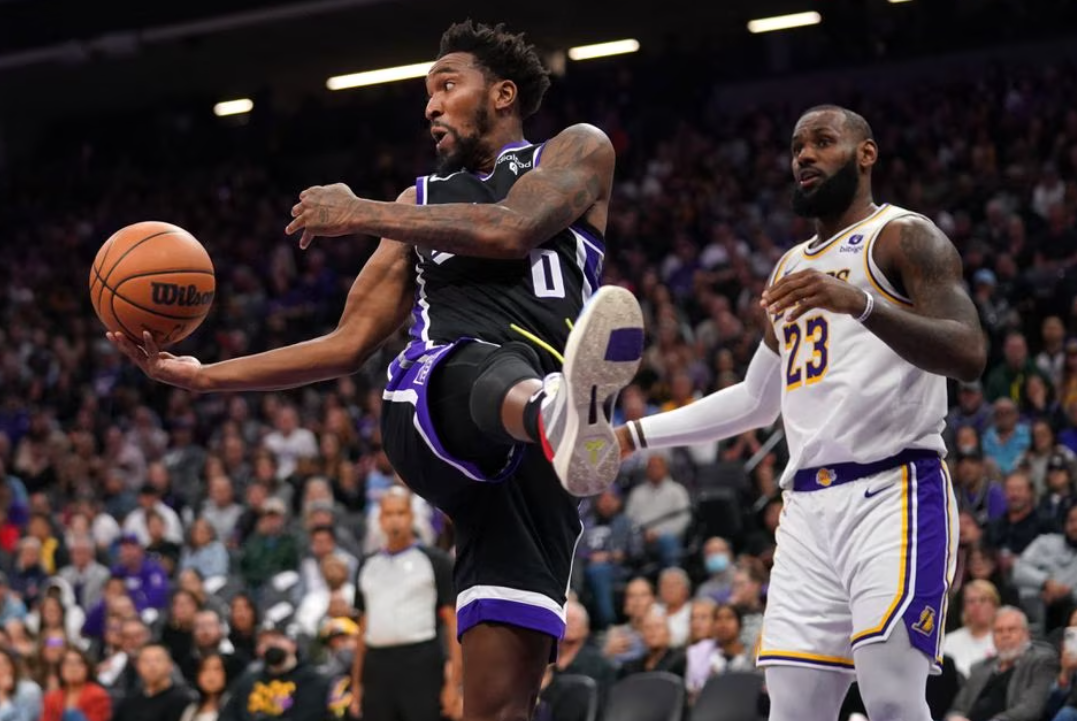 Sacramento Kings guard Malik Monk (0) passes the ball in front of Los Angeles Lakers forward LeBron James (23) in the fourth quarter at the Golden 1 Center in Sacramento, California, Oct. 29, 2023.