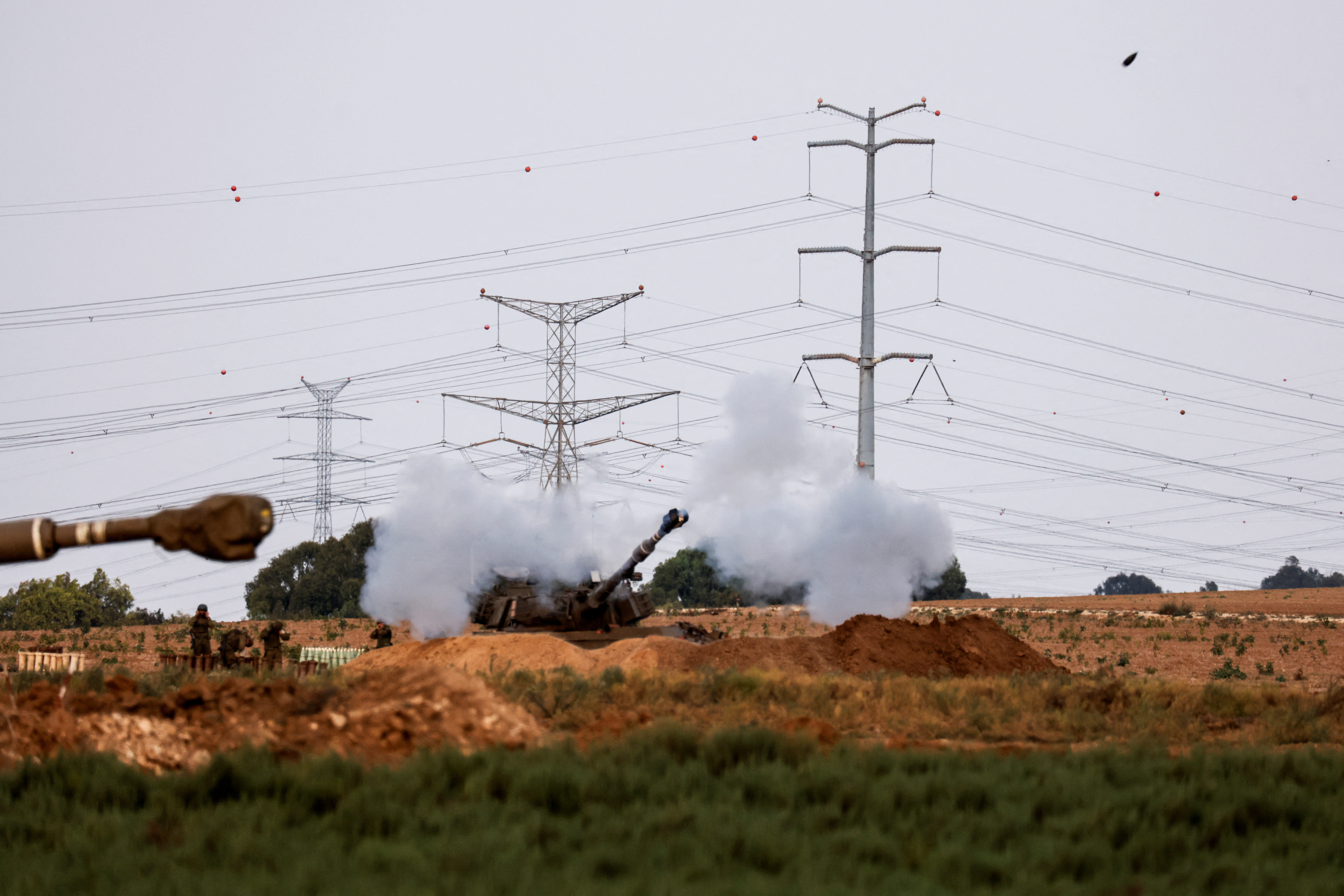 An artillery unit fires near the Israeli side of the border between Israel and the Gaza Strip, October 8, 2023. 