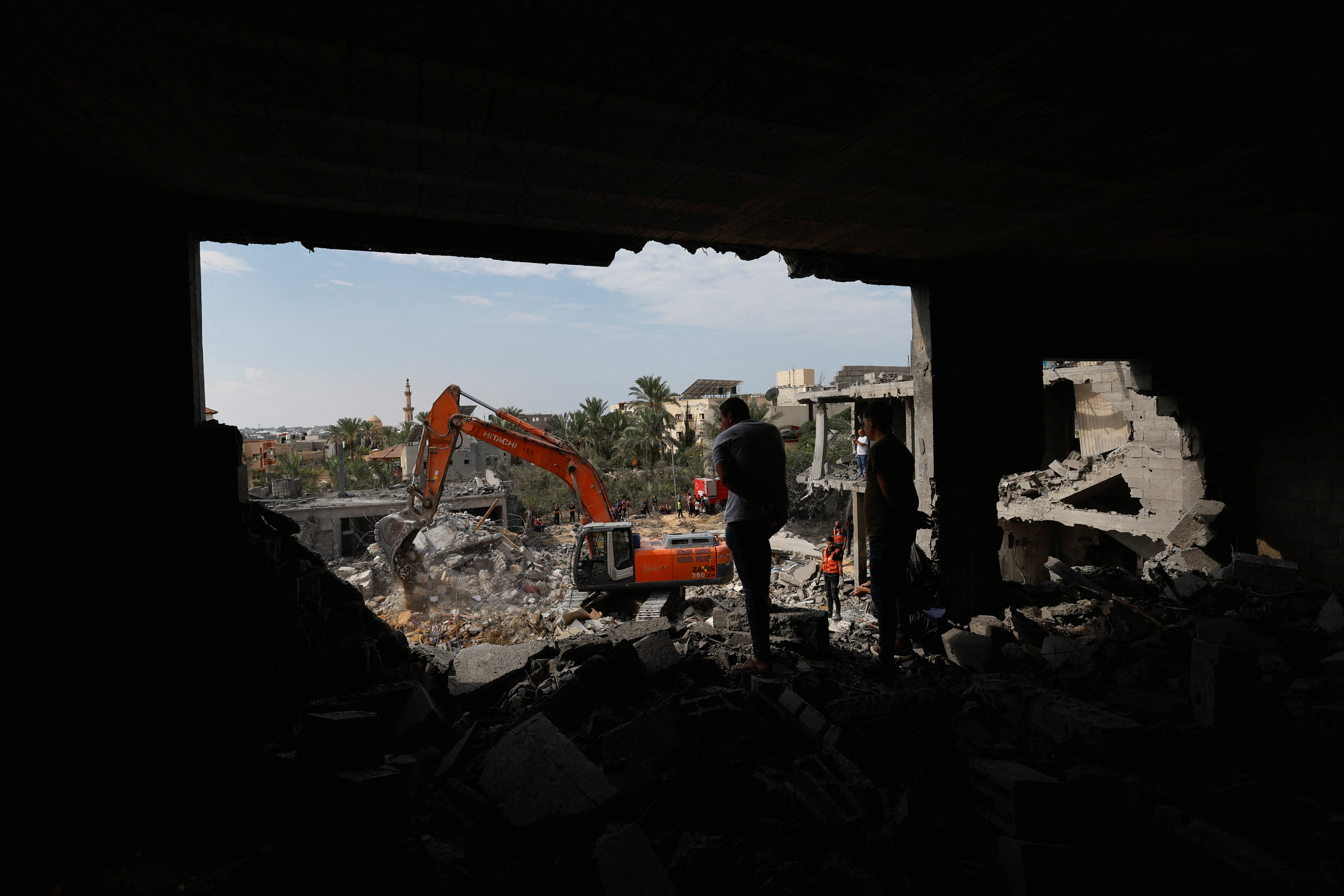 Palestinians search for casualties under the rubble at a site of a house destroyed by Israeli strikes in Khan Younis in the southern Gaza Strip October 16, 2023. 