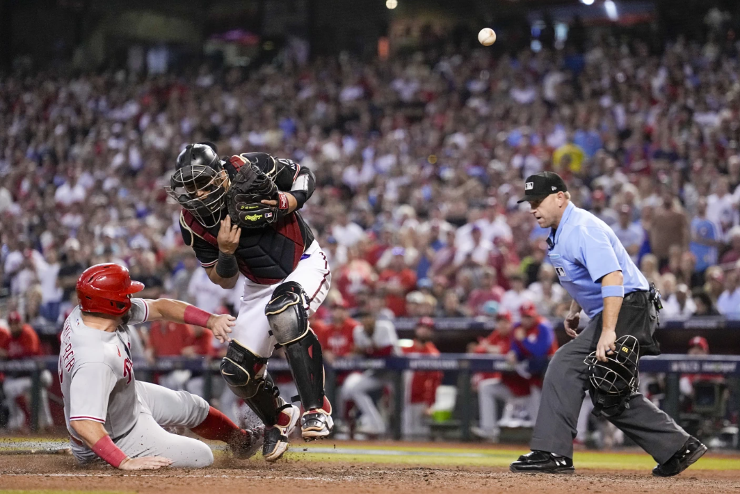 Philadelphia Phillies’ Kyle Schwarber is safe at home past Arizona Diamondbacks catcher Gabriel Moreno on a hit by Alec Bohm during the sixth inning in Game 4 of the NL Championship Series in Phoenix, Friday, Oct. 20, 2023.