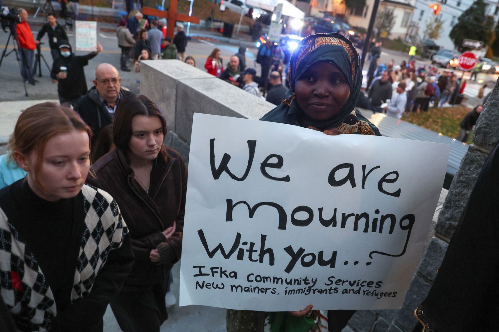 A person holds a placard as mourners take part in a vigil for the victims of the deadly mass shooting outside the Basilica of Saints Peter and Paul, in Lewiston, Maine, U.S., October 29, 2023. 