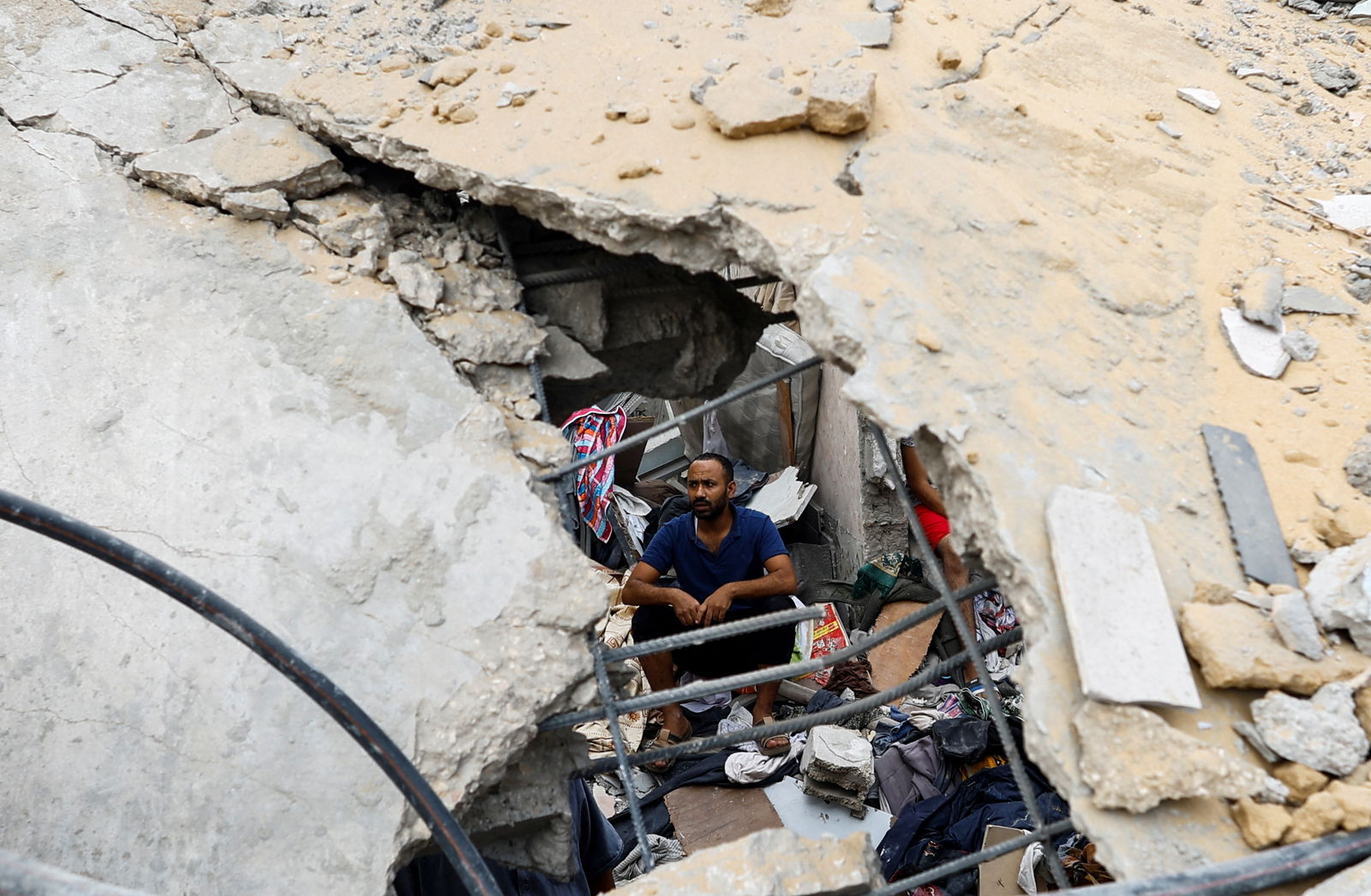 A Palestinian man sits amidst the rubble at the site of Israeli strikes on houses, amid the ongoing conflict between Israel and Palestinian Islamist group Hamas, in Khan Younis in the southern Gaza Strip, October 29, 2023. 