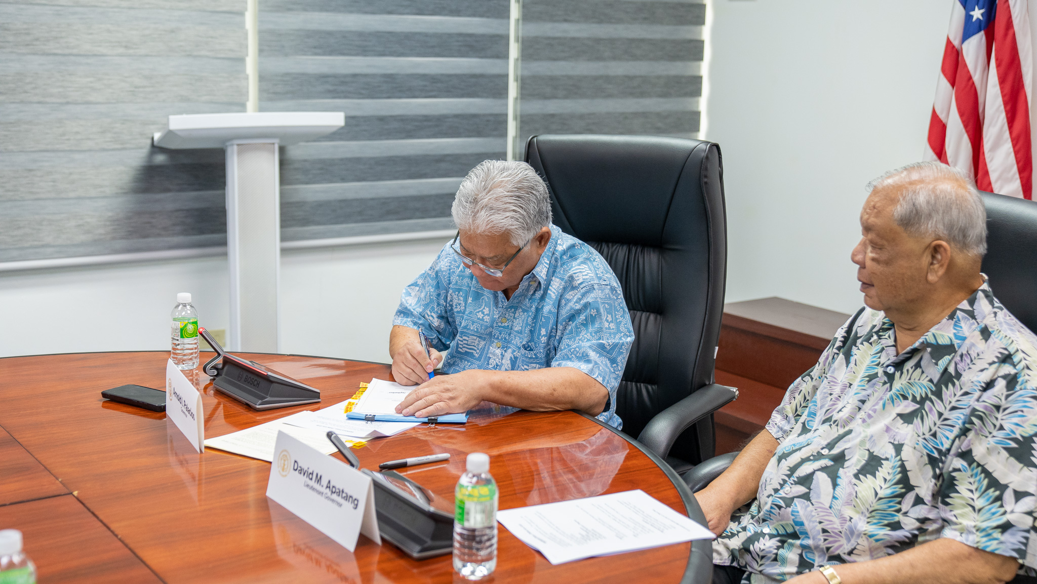 Gov. Arnold I. Palacios signs the fiscal year 2024 budget as Lt. Gov. David M. Apatang looks on in the governor's conference room on Saturday.