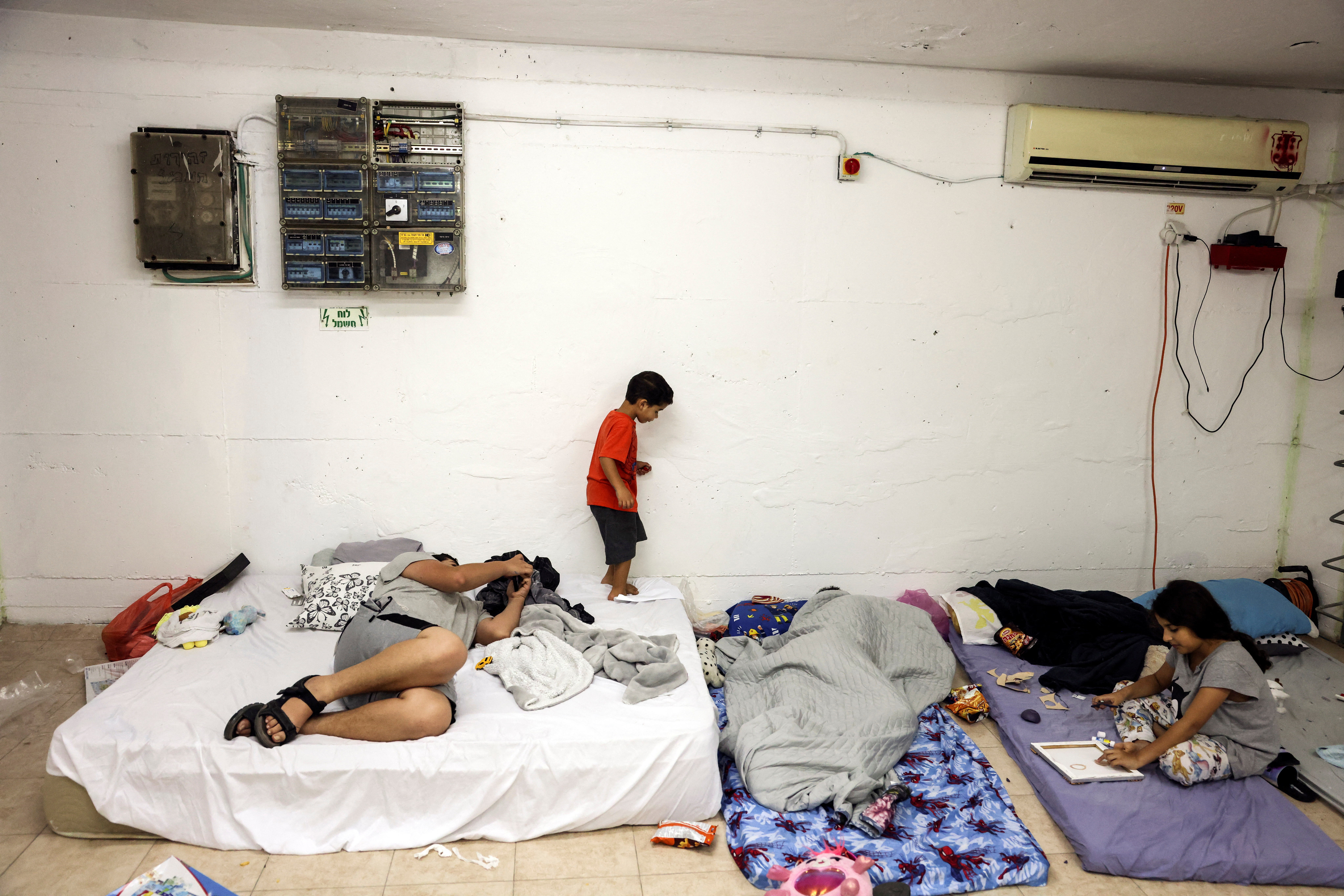 Israelis wait on mattresses in a bomb shelter as rockets from Gaza are launched towards Israel in Ashkelon, southern Israel October 8, 2023. 