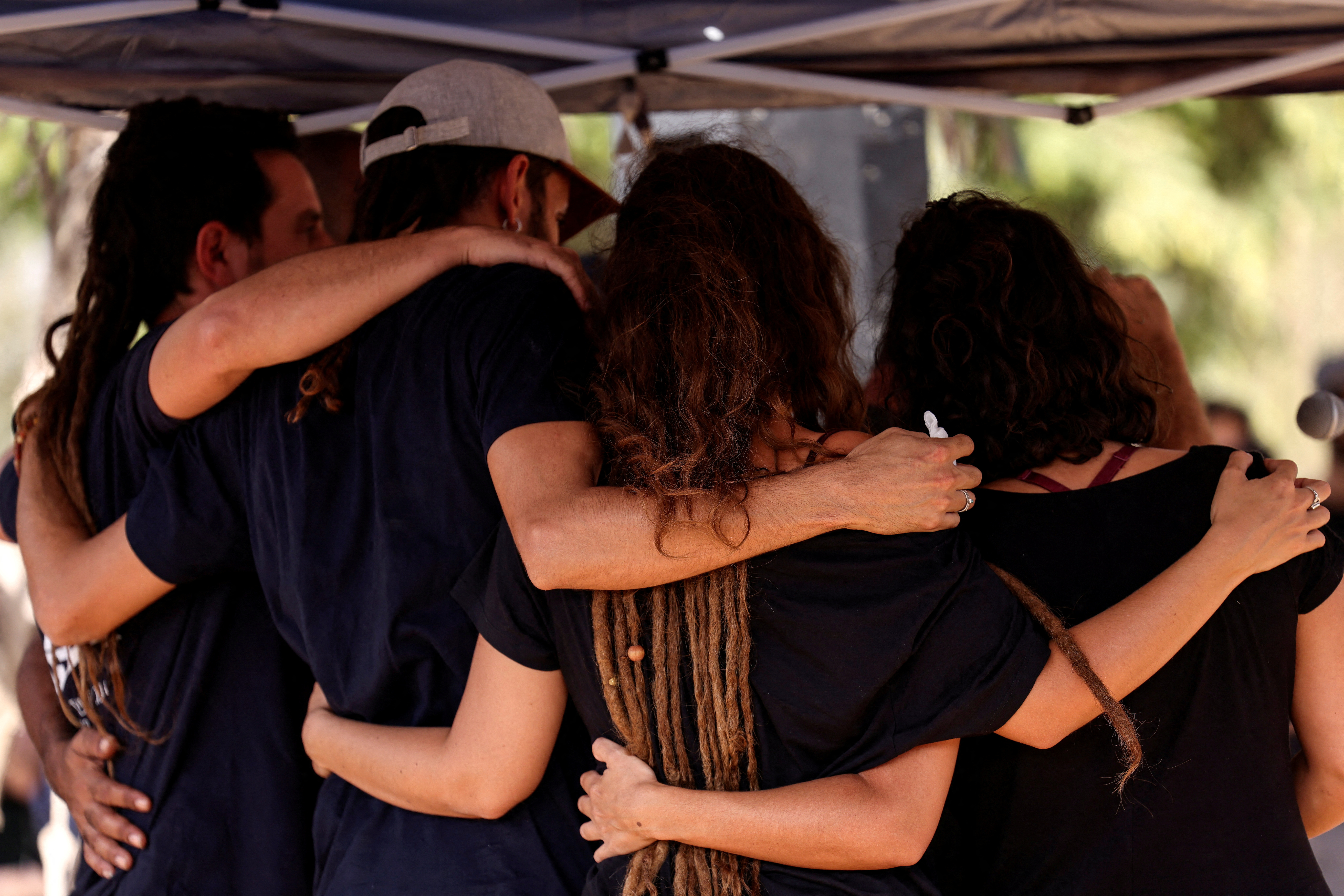 Mourners comfort each other during the funeral of Mayan and Yuval Bar who were killed in Kibbutz Beeri following a deadly infiltration by Hamas gunmen, at Kibbutz Revivim, Israel, October 22, 2023. 