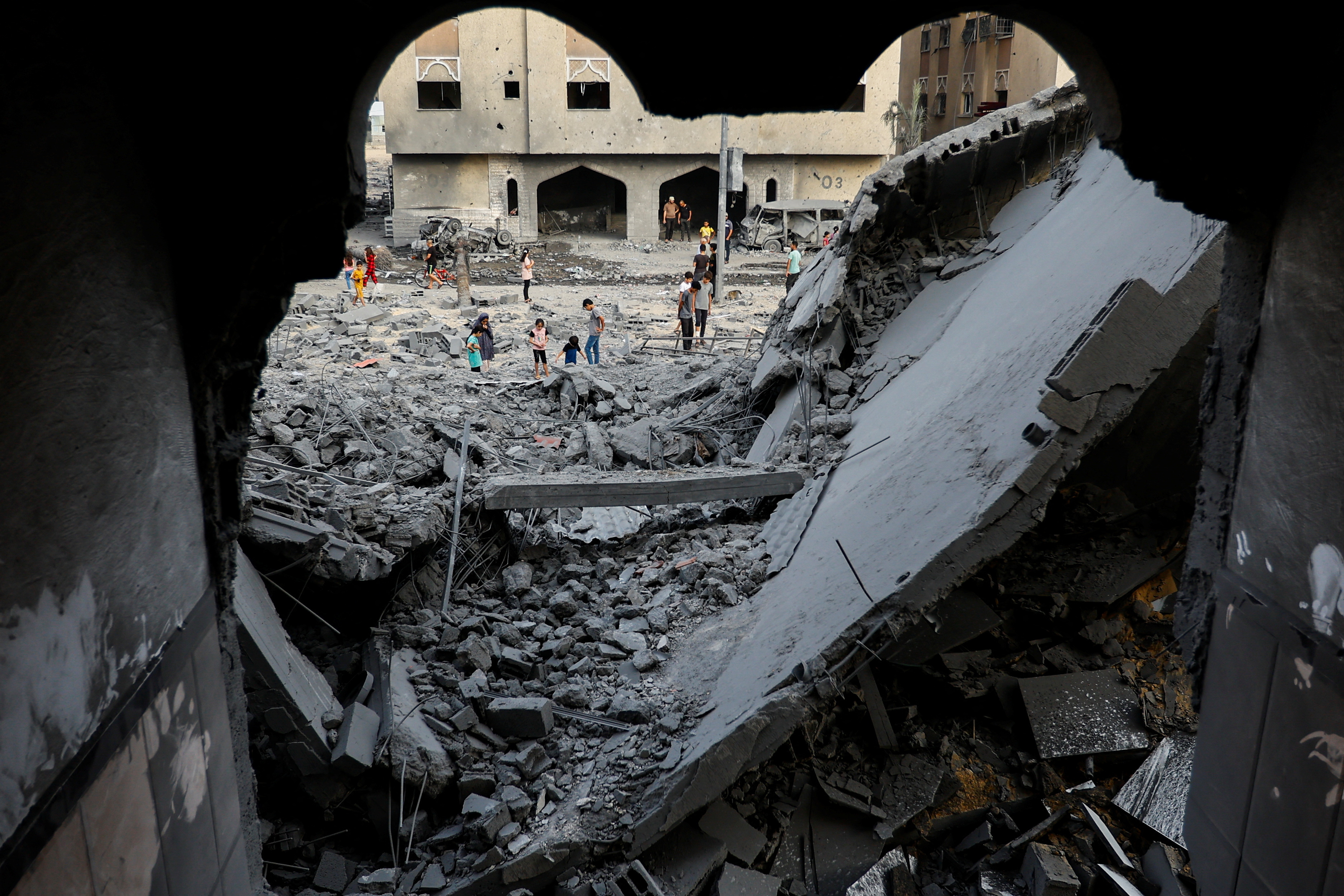 Palestinians inspect the site of Israeli strikes on a house in Khan Younis in the southern Gaza Strip, October 23, 2023. 