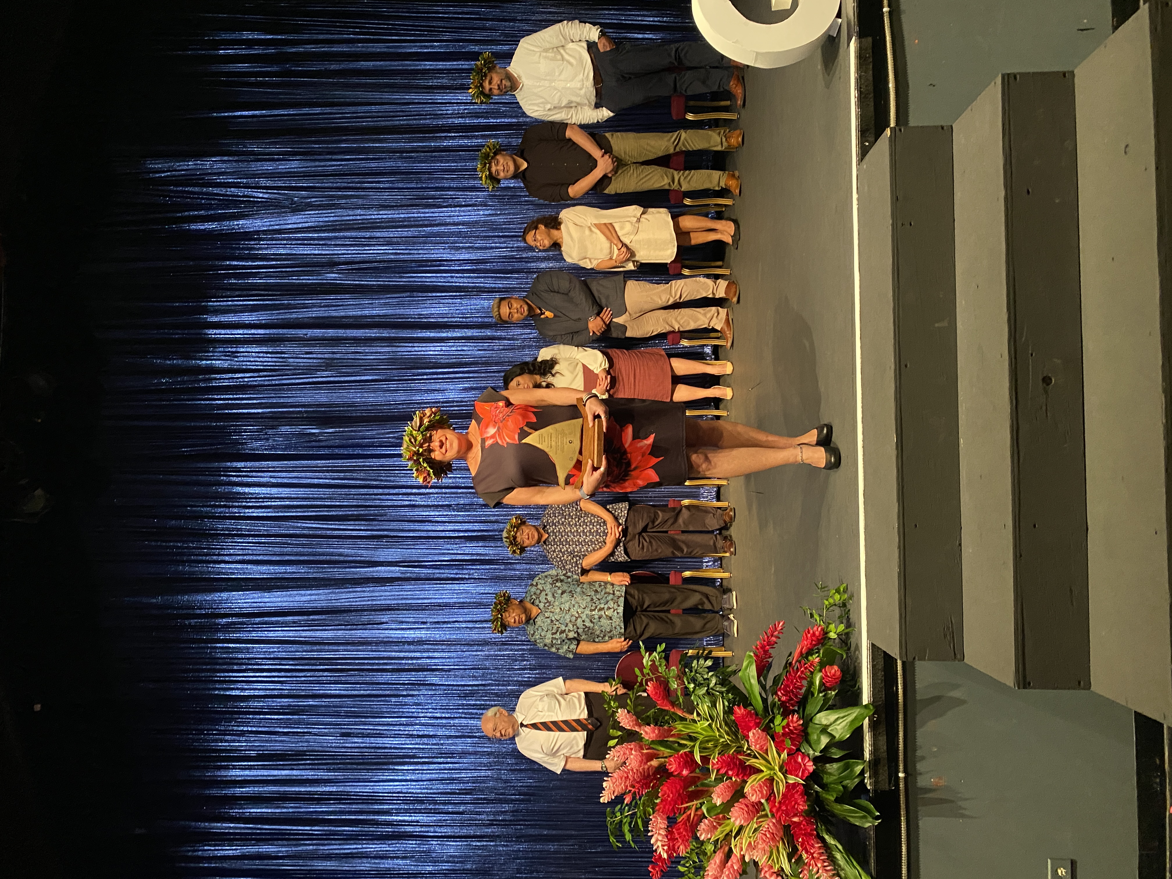 Ajani Burrell's wife, Sarah Forti, accepts the award on her husband's behalf. Burrell is on sabbatical leave.