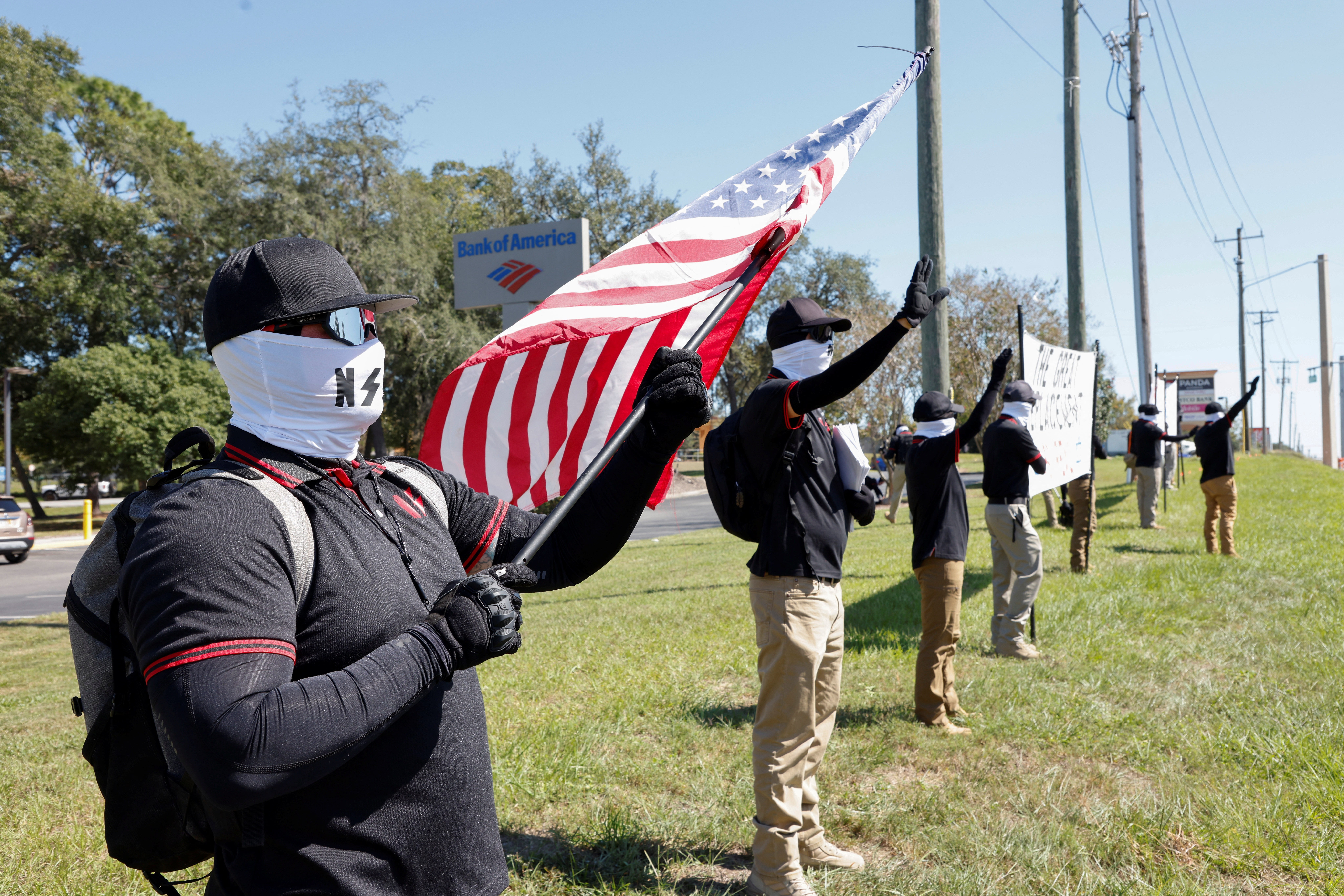 Members of the white nationalist group NatSoc Florida wave to motorists as they hold banners against U.S. support for Israel, during the Israeli-Hamas conflict, in Lady Lake, Florida, U.S., October 21, 2023. 