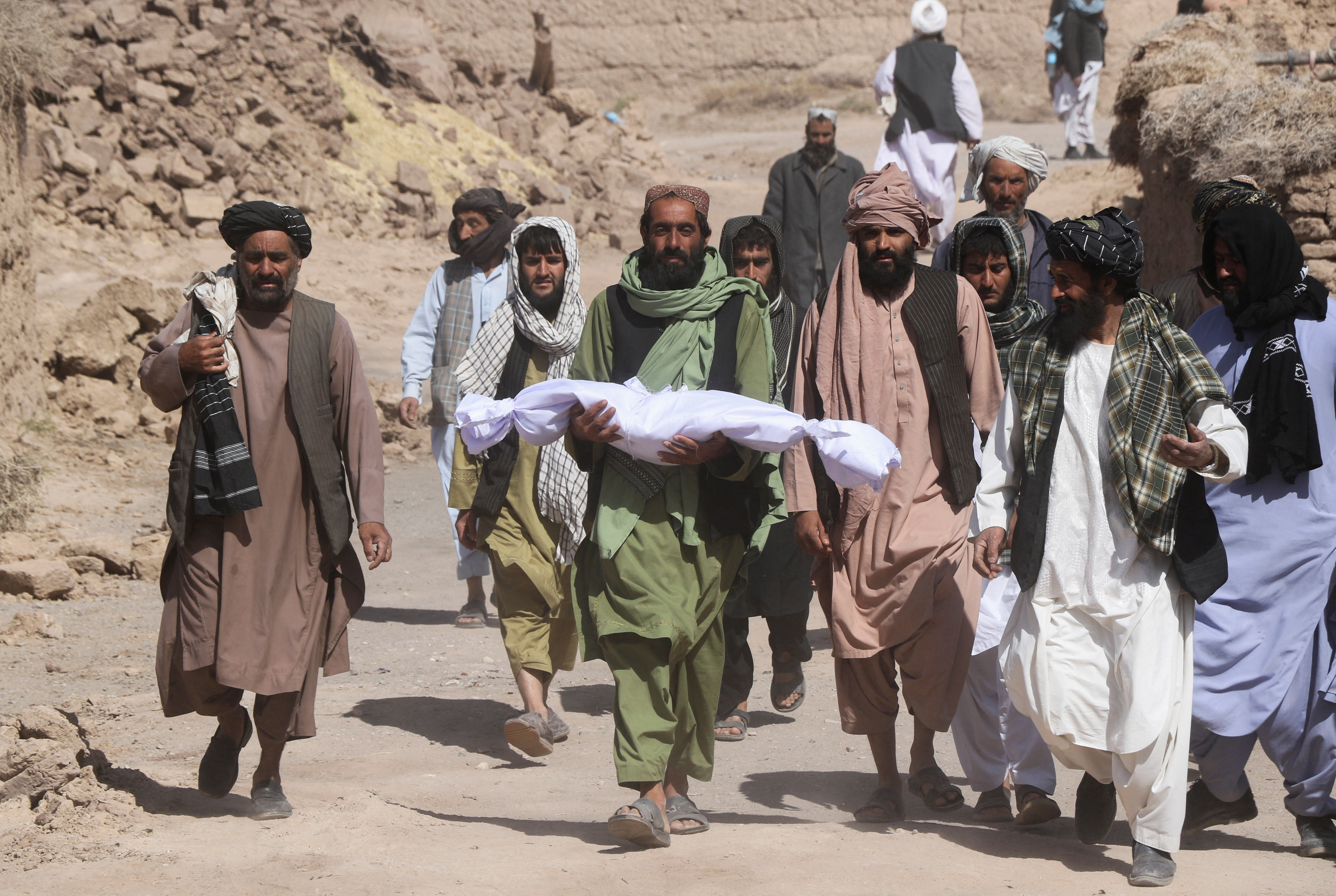 A man carries a body of his child, in the aftermath of an earthquake in the district of Zendeh Jan, in Herat, Afghanistan October 8, 2023.