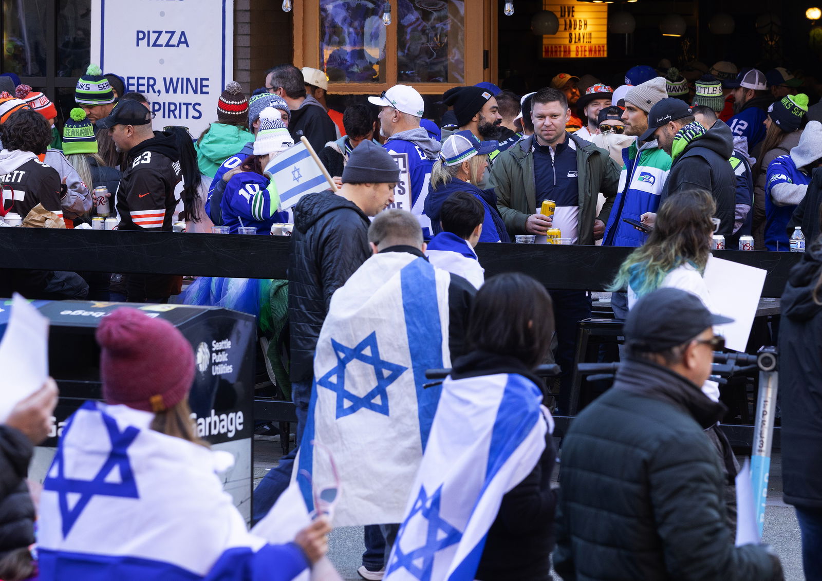 Demonstrators in support of Israel and releasing its hostages, foreground, march past fans at a bar en route to Lumen Field before start of a Seattle Seahawks NFL game on Sunday, Oct. 29, 2023, in Seattleâ€™s Pioneer Square neighborhood. (Ken Lambert/The Seattle Times/TNS)