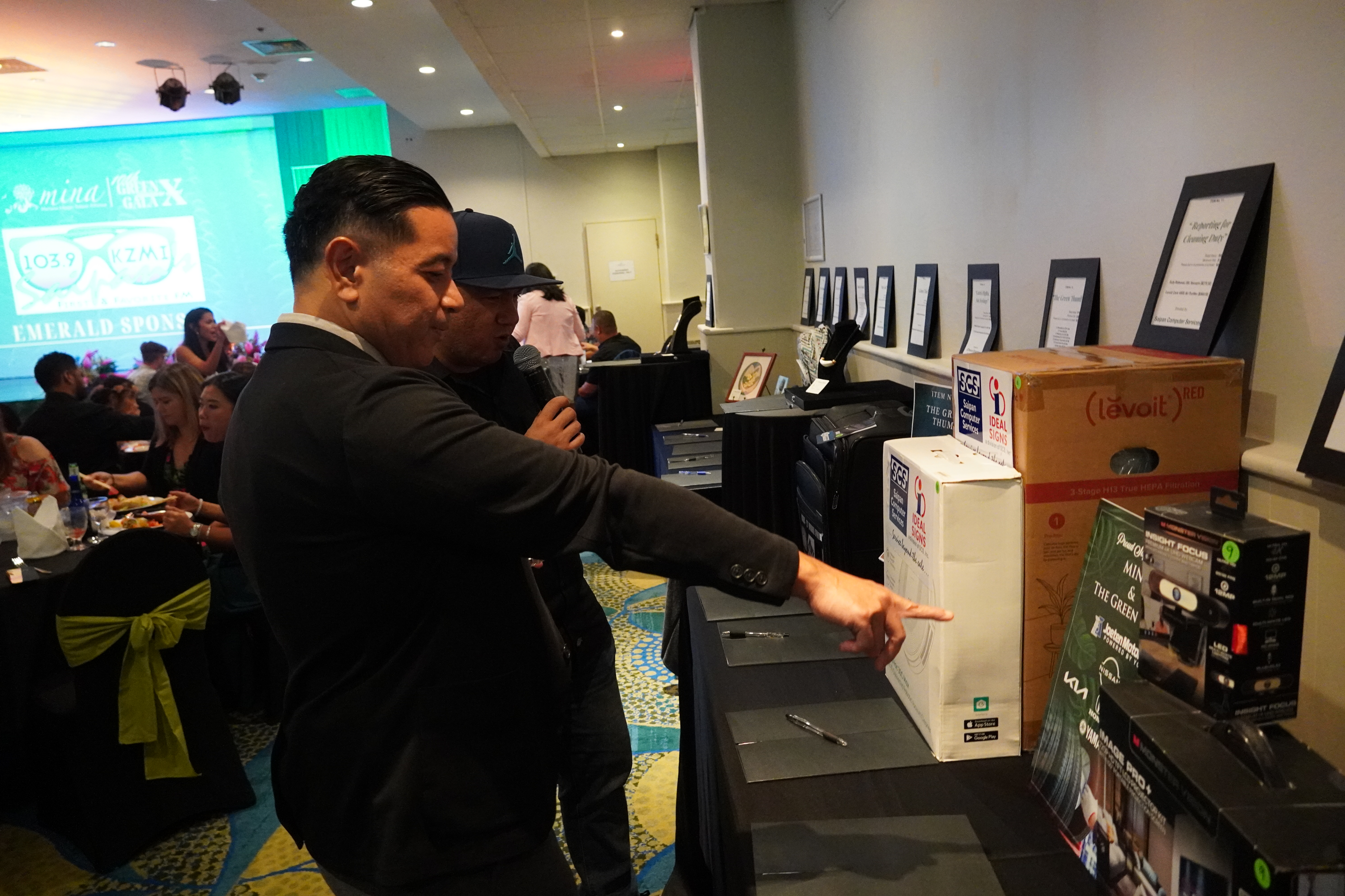 Frankie Eliptico points to an item available for auction at the Green Gala.
