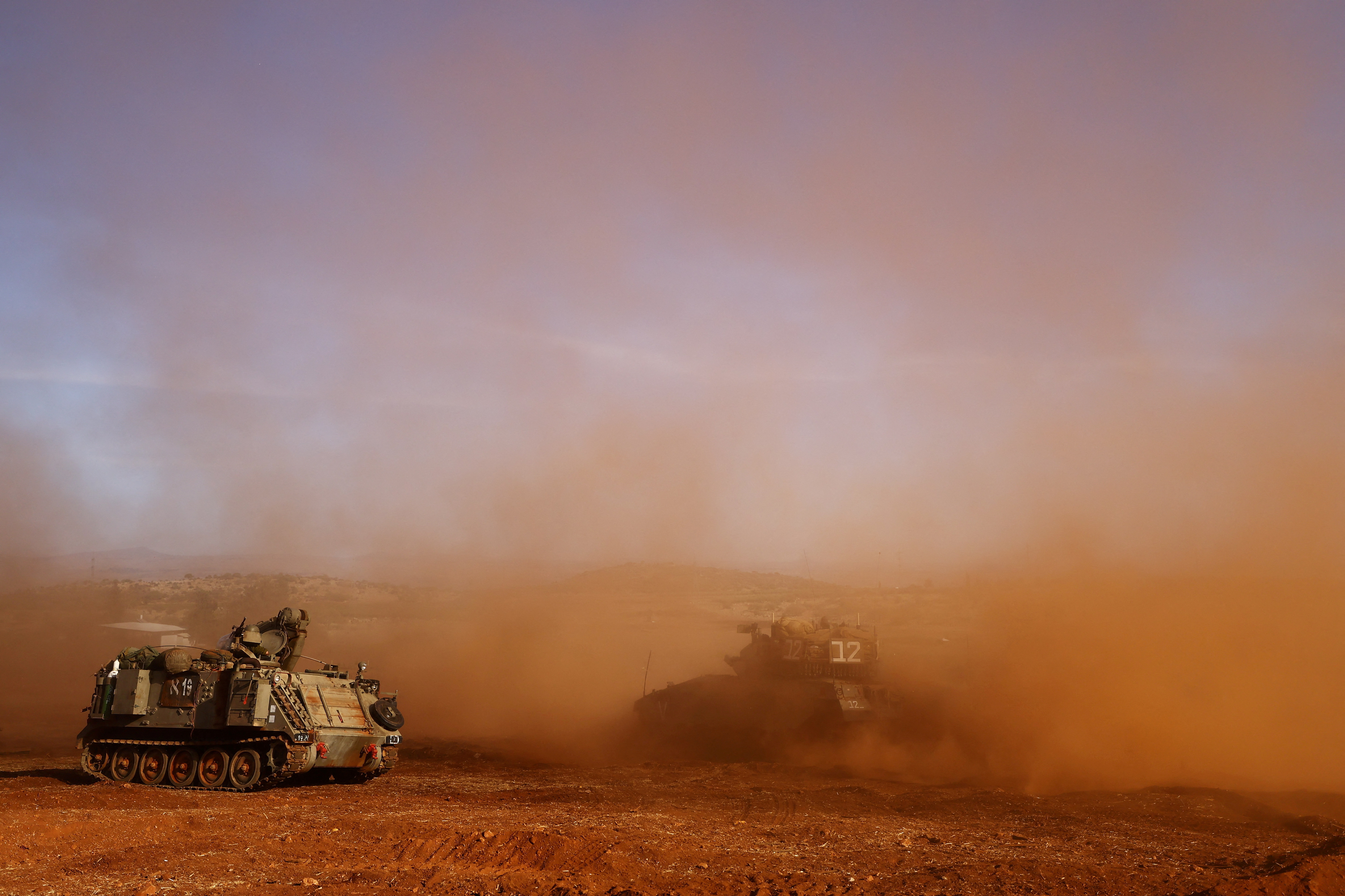 An Israeli armored personnel carrier (APC) and an Israeli tank participate in a drill near Israel's border with Lebanon in northern Israel, October 26, 2023. 