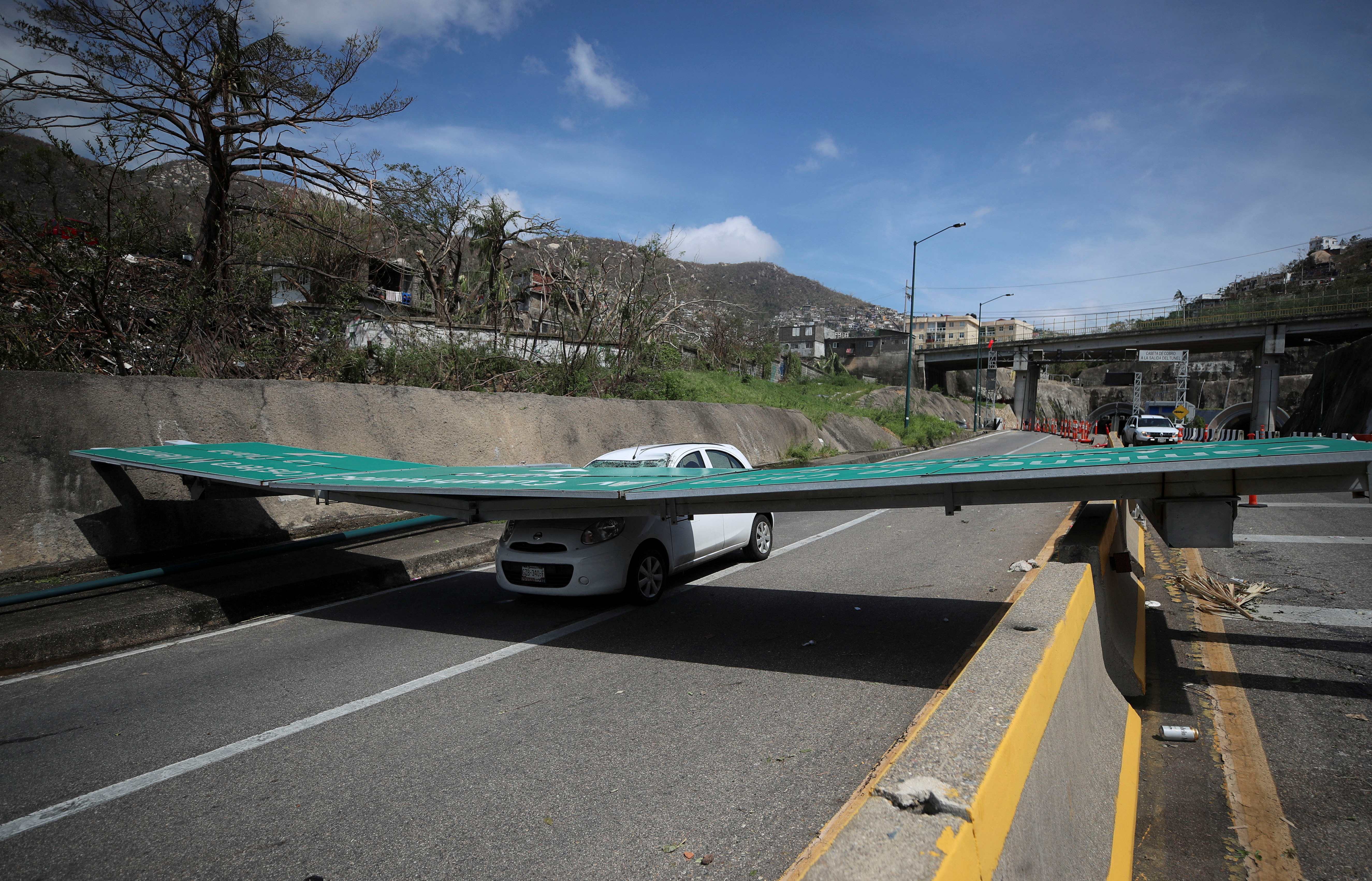 A street sign that has fallen on a car is pictured in the aftermath of Hurricane Otis in Acapulco, Mexico, October 26, 2023. 
