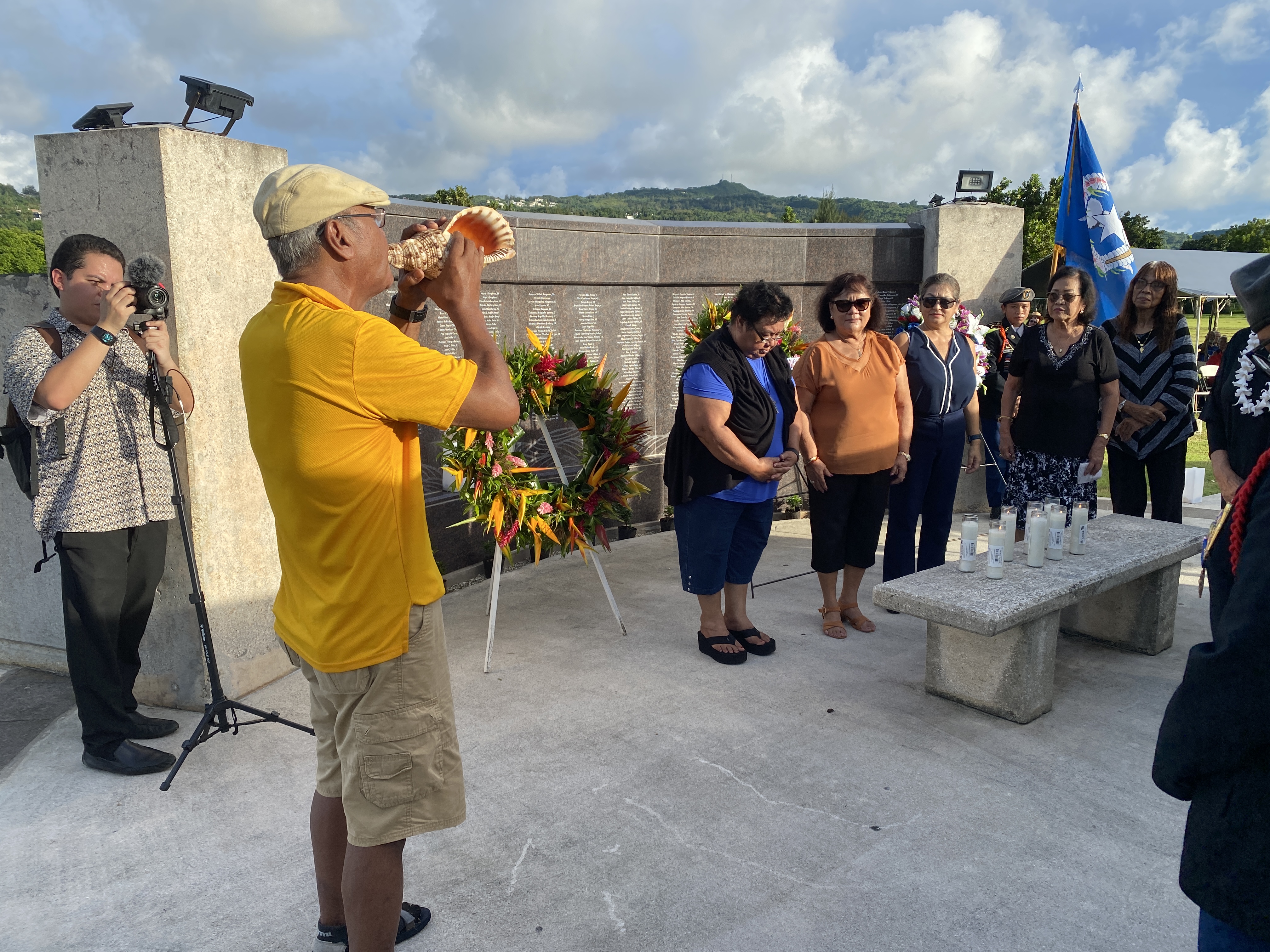 Luis Kapileo blows a kulu, a conch shell, during the candle lighting ceremony.