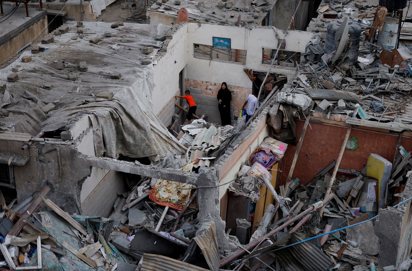 Palestinians check the damage at the site of Israeli strikes on houses, amid the ongoing conflict between Israel and Palestinian Islamist group Hamas, in Khan Younis in the southern Gaza Strip, October 29, 2023. 