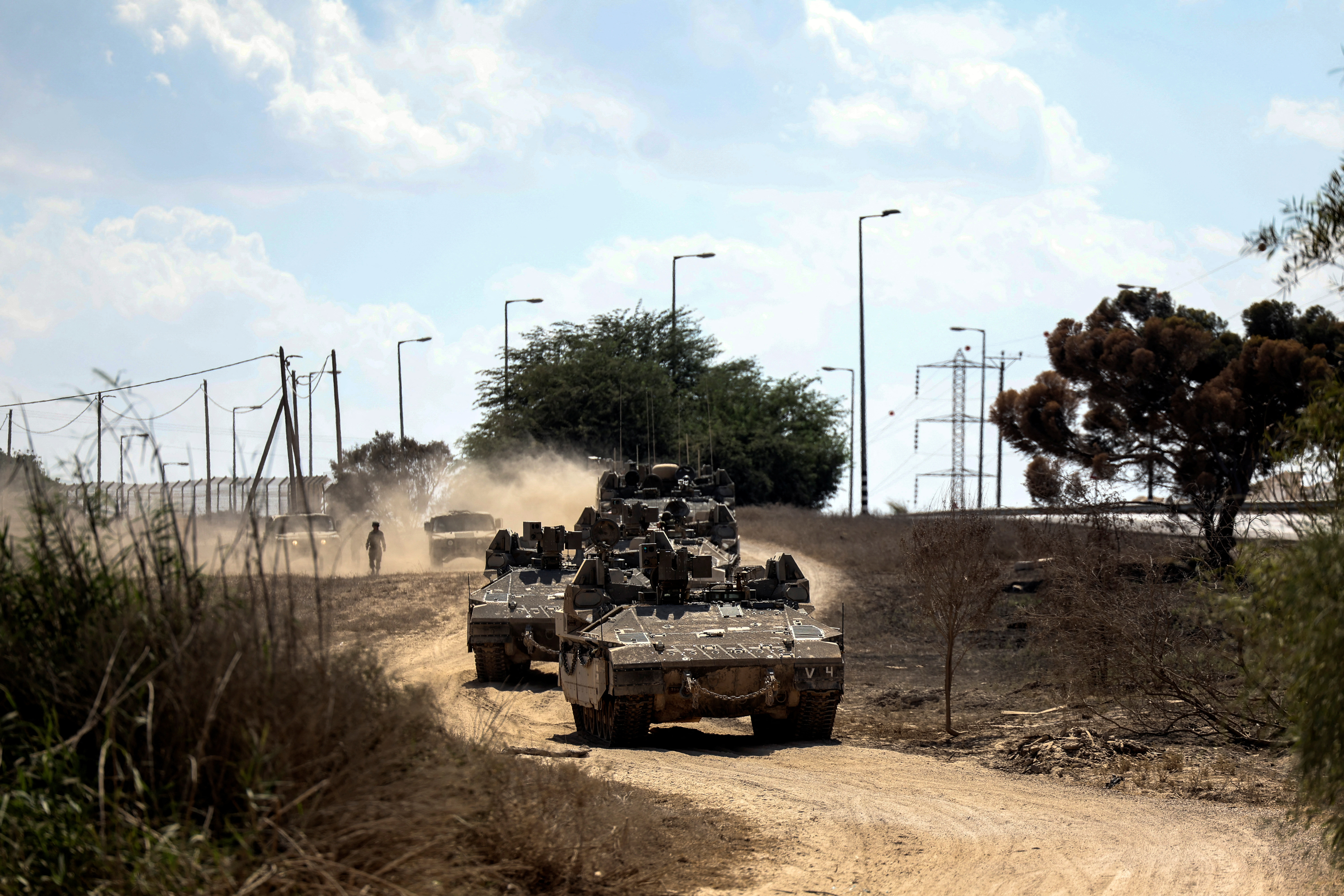 Israeli military vehicles drive near Israel's border with the Gaza Strip, in southern Israel, October 15, 2023. 