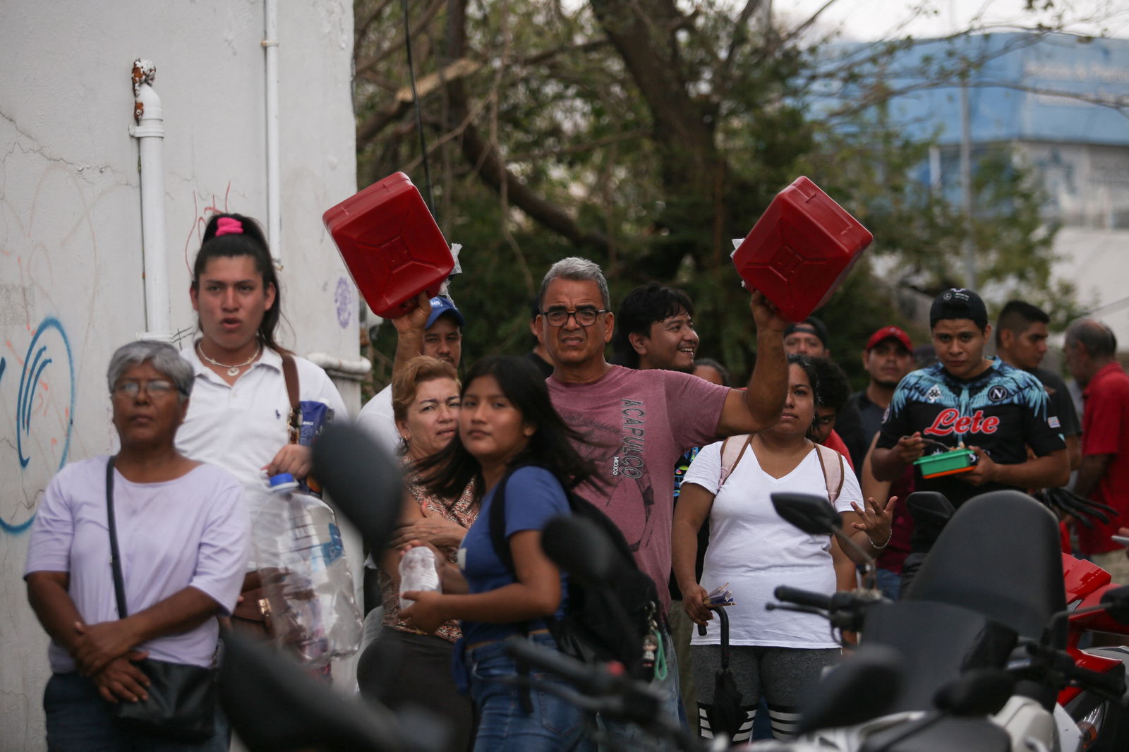People carry gallons to fill up with gasoline in the aftermath of Hurricane Otis, in Acapulco, Mexico, October 28, 2023. 