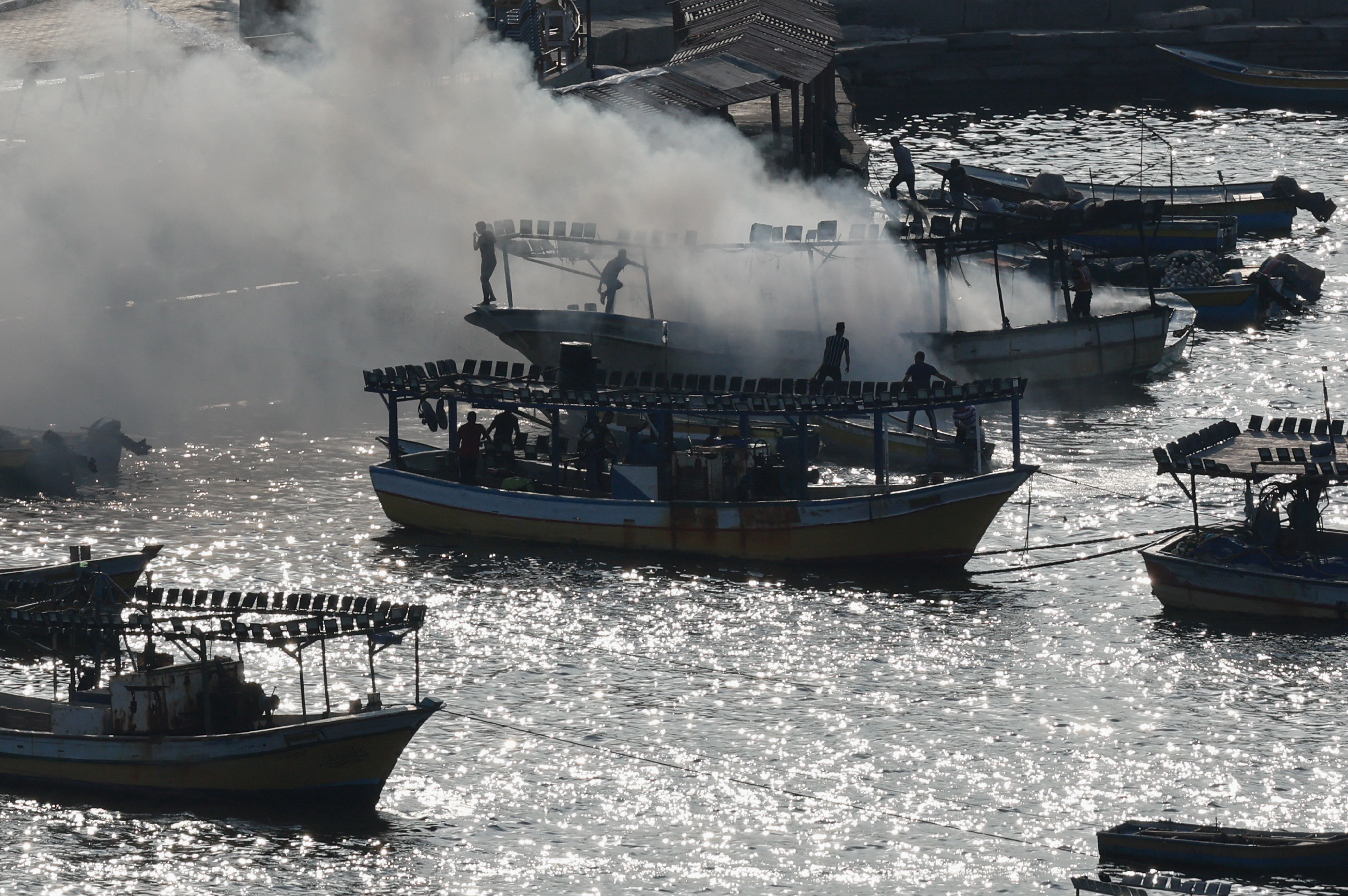Smoke billows from a boat following Israeli strikes, at the seaport of Gaza City, October 8, 2023. 