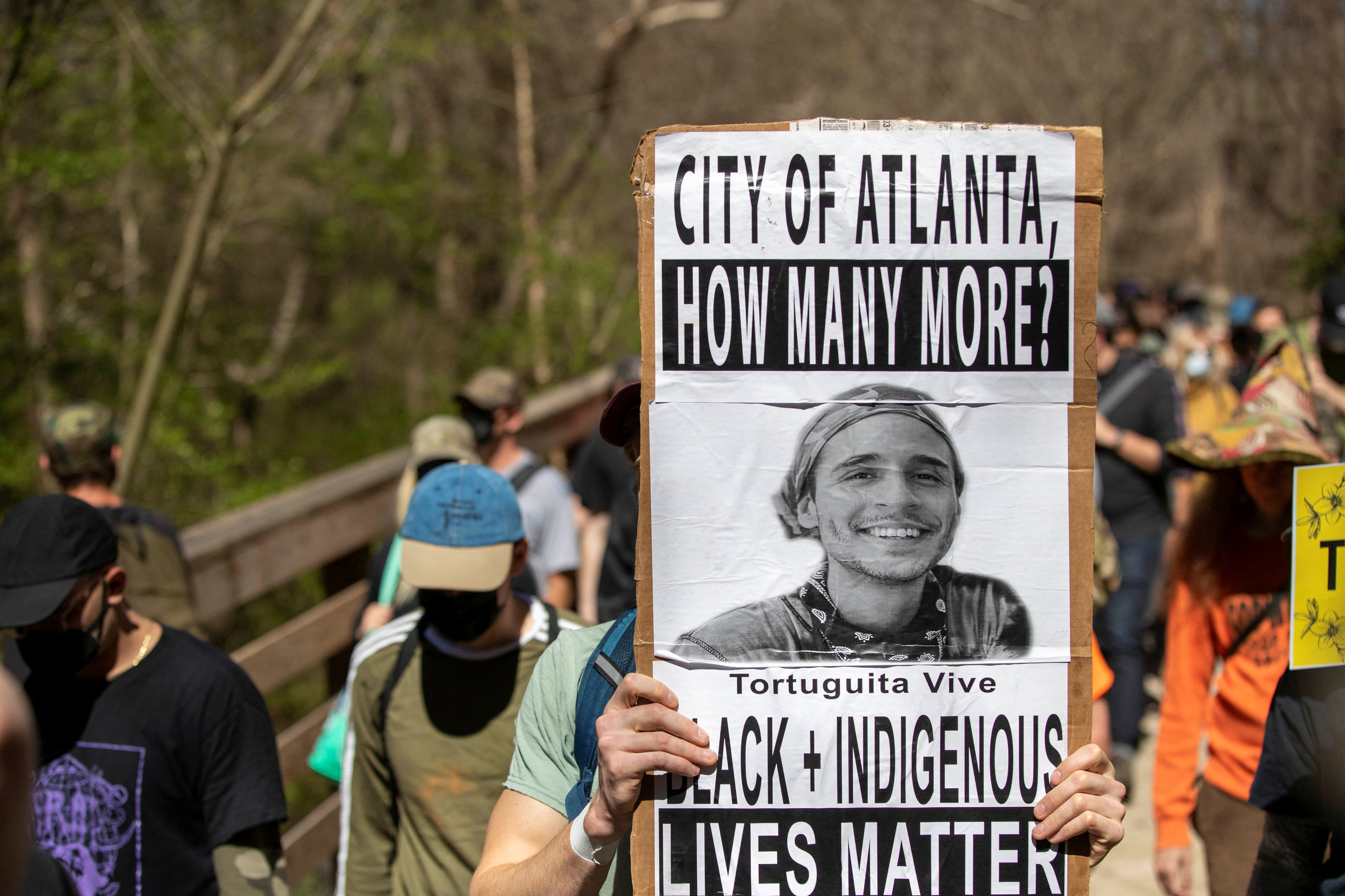 A person holds a sign for Manuel "Tortuguita" Paez Teran, a man that was shot and killed by police officers near the proposed building site for the Atlanta public training facility, during a march to Defend The Atlanta Forest on the South River Trail in Atlanta, Georgia, March 4, 2023. 