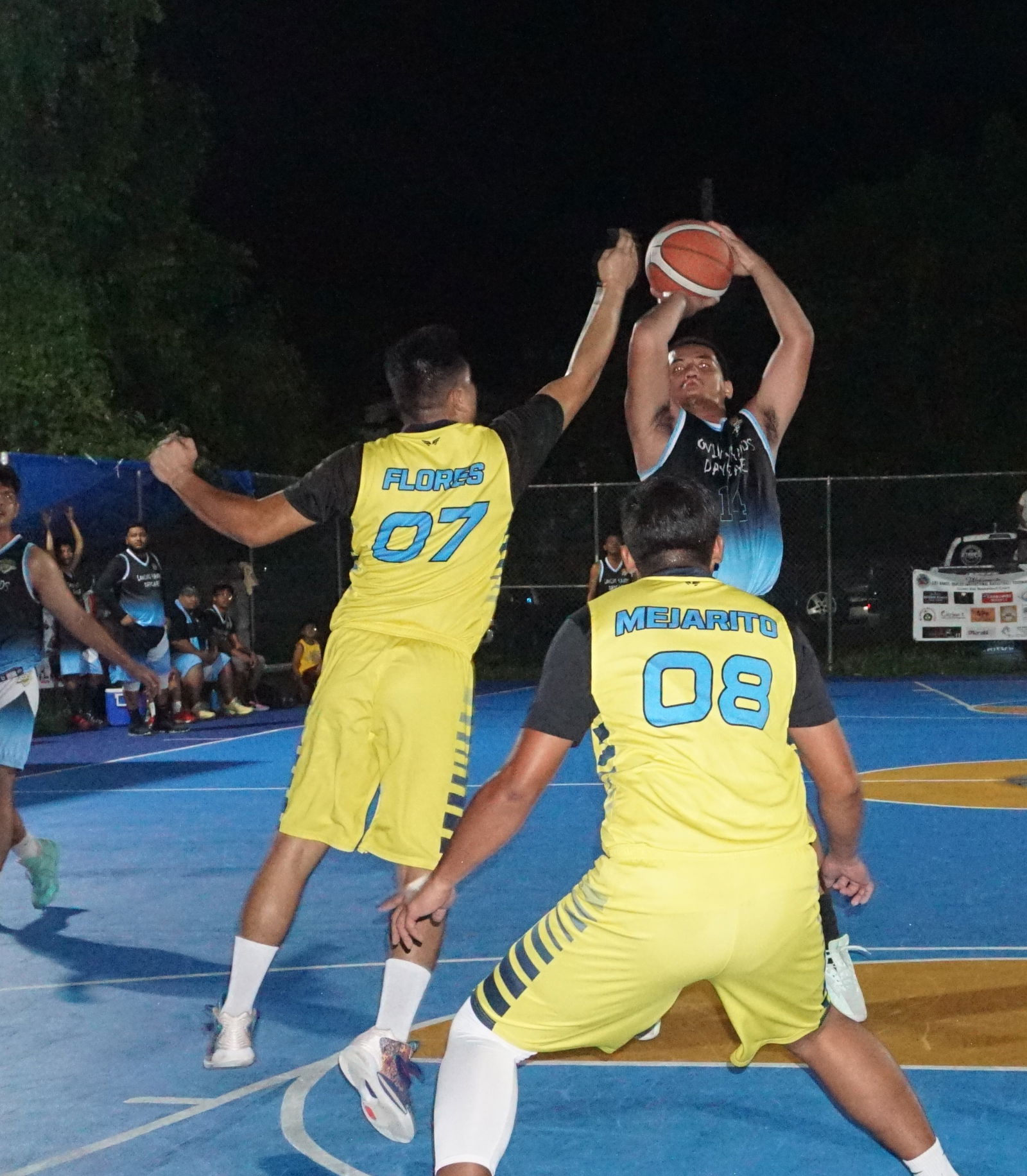 Loving Hands' Rafael Ordona pulls up for the jumpshot against two defenders during an open division game of the 2023 Saipan Magalahi Eagles Club Invitational Basketball League at the Gualo Rai basketball court.