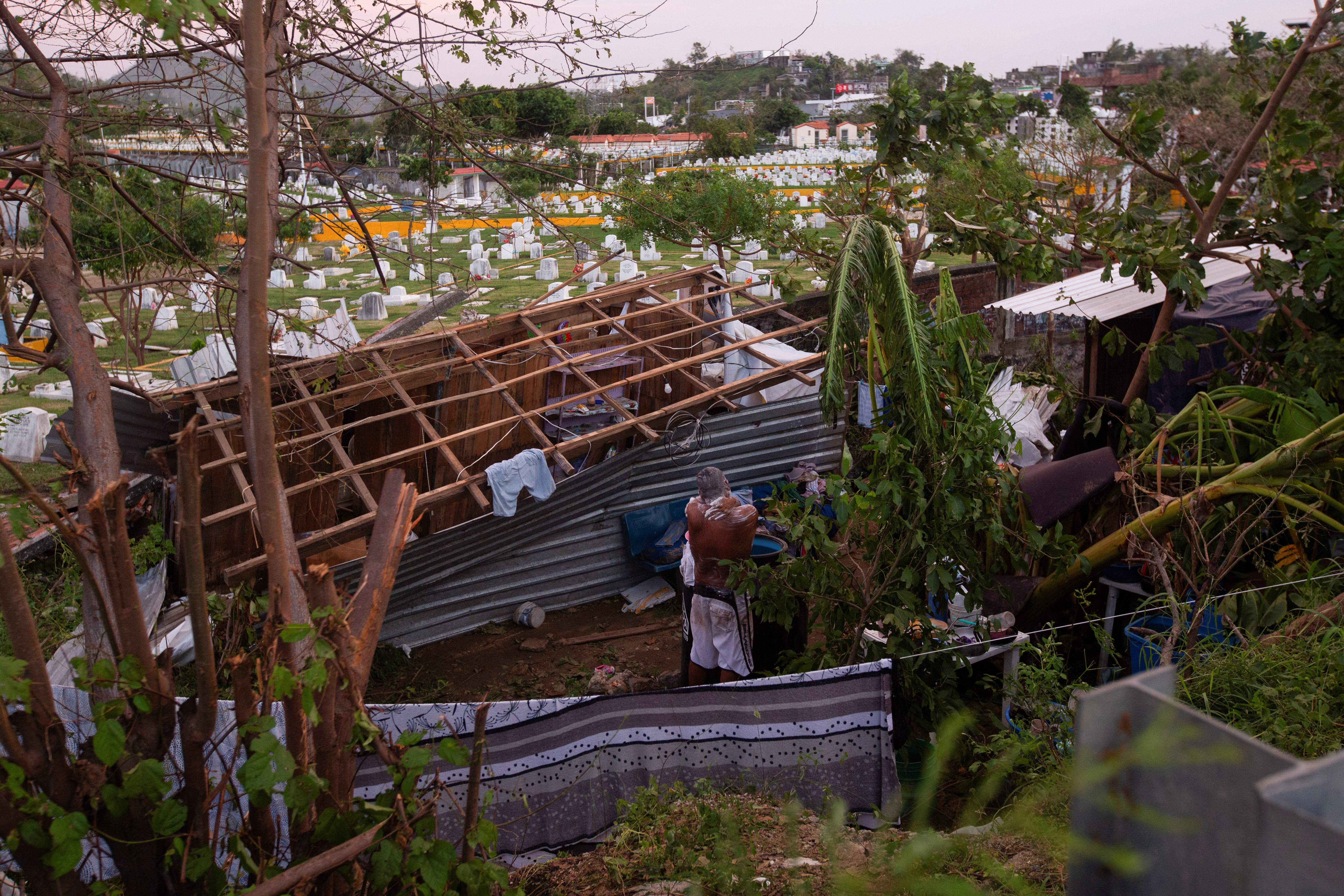 A man bath next to a damaged structure in the aftermath of Hurricane Otis near Acapulco, Mexico, October 26, 2023. 