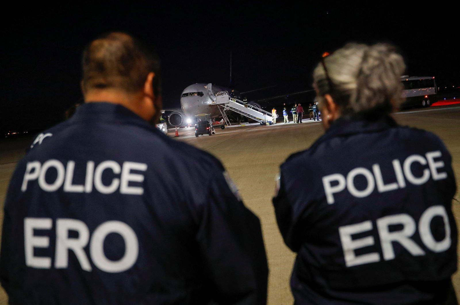 Officers of the U.S. Enforcement an Removal Operations (ERO) stand near an aircraft on which Venezuelan migrants will be repatriated as part of an immigration enforcement process, at the Valley International Airport, in Harlingen, Texas, U.S. October 18, 2023. 