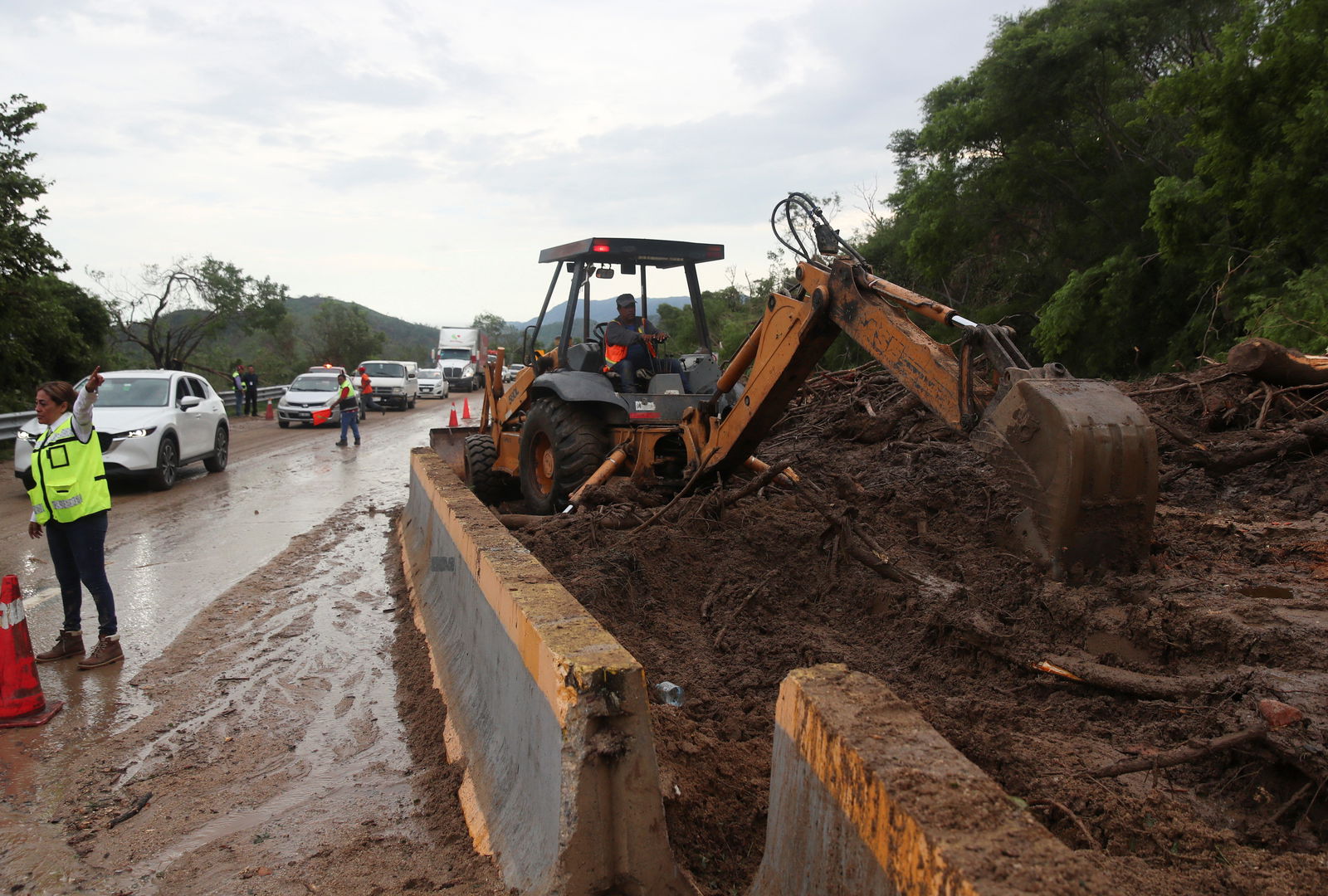 A worker operating heavy machinery clears debris and mud left by Hurricane Otis after it hit, on a road leading to Acapulco, in the Mexican state of Guerrero, Mexico October 25, 2023. 