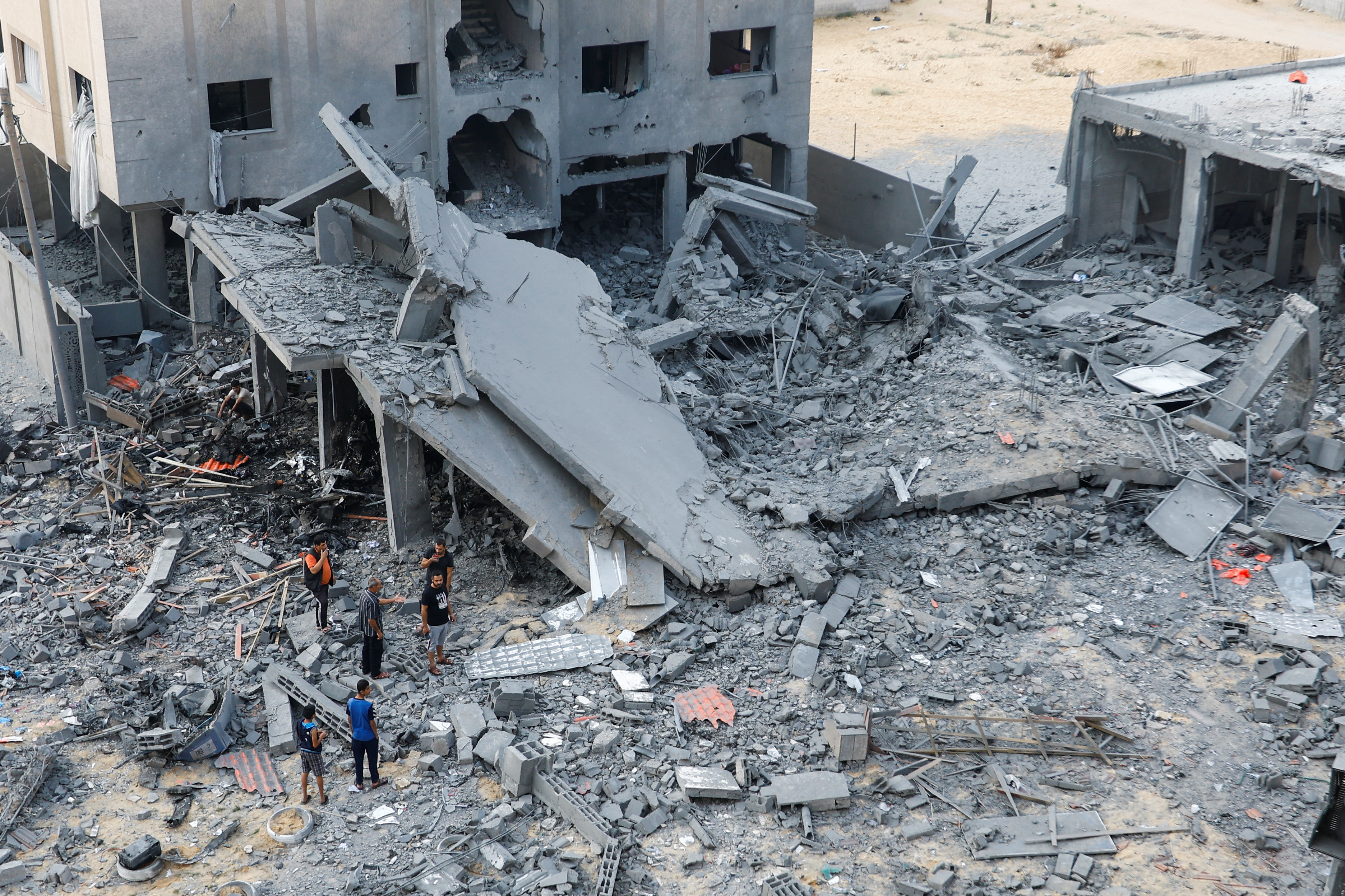 Palestinians inspect the site of Israeli strikes on a house in Khan Younis in the southern Gaza Strip, October 23, 2023. 