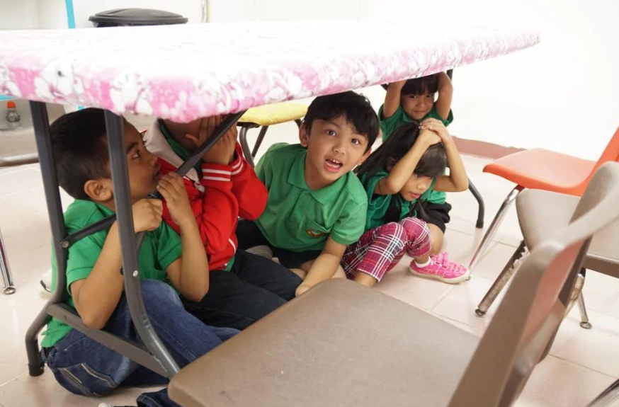  Students of Jana Mendiola's first grade CHamoru class get under the table as part of the Great Guam ShakeOut in 2018, at D.L. Perez Elementary School in Yigo. The Great Guam ShakeOut is an islandwide exercise to teach people what to do in case of an earthquake. David Castro/The Guam Daily Post