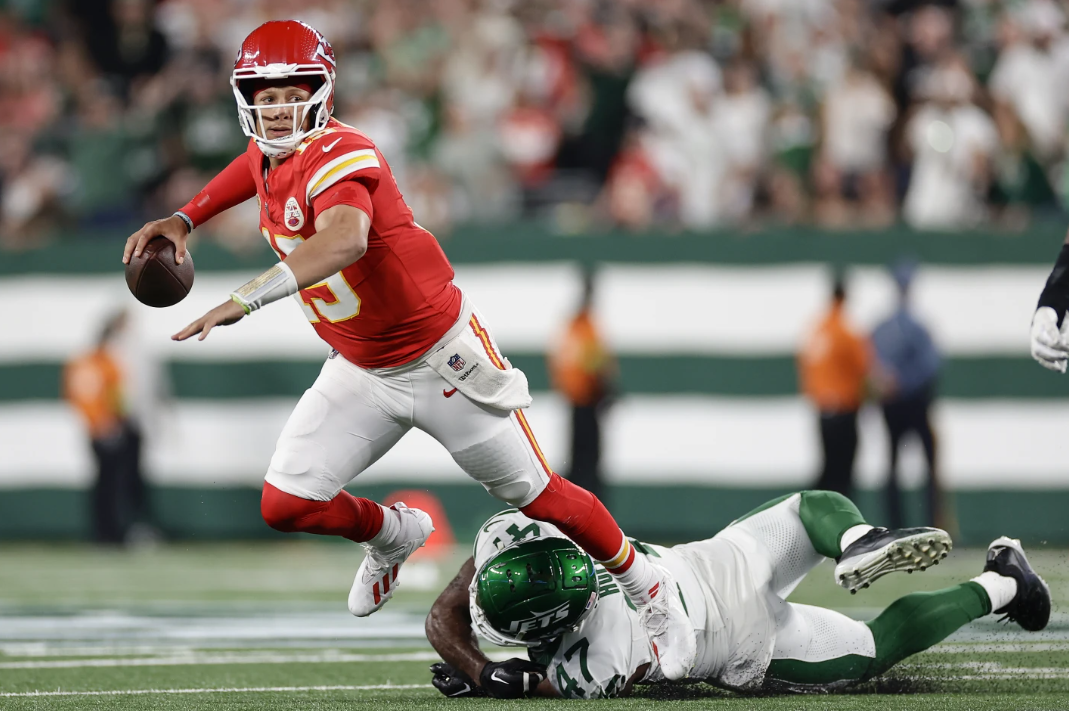 Kansas City Chiefs quarterback Patrick Mahomes is tripped up by New York Jets linebacker Bryce Huff as Mahomes throws during the second quarter of an NFL football game, Sunday, Oct. 1, 2023, in East Rutherford, N.J.