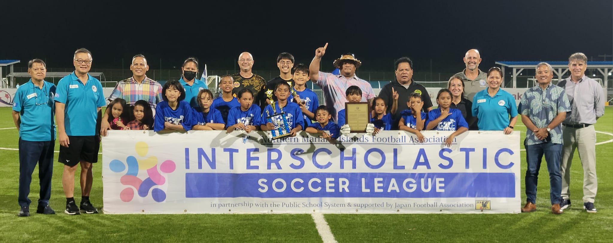 Koblerville Elementary School players pose for a photo with  NMI Football Association officials after winning the elementary school division title of the NMIFA Interscholastic Soccer League SY23-24 at the NMI Soccer Training Center on Wednesday.