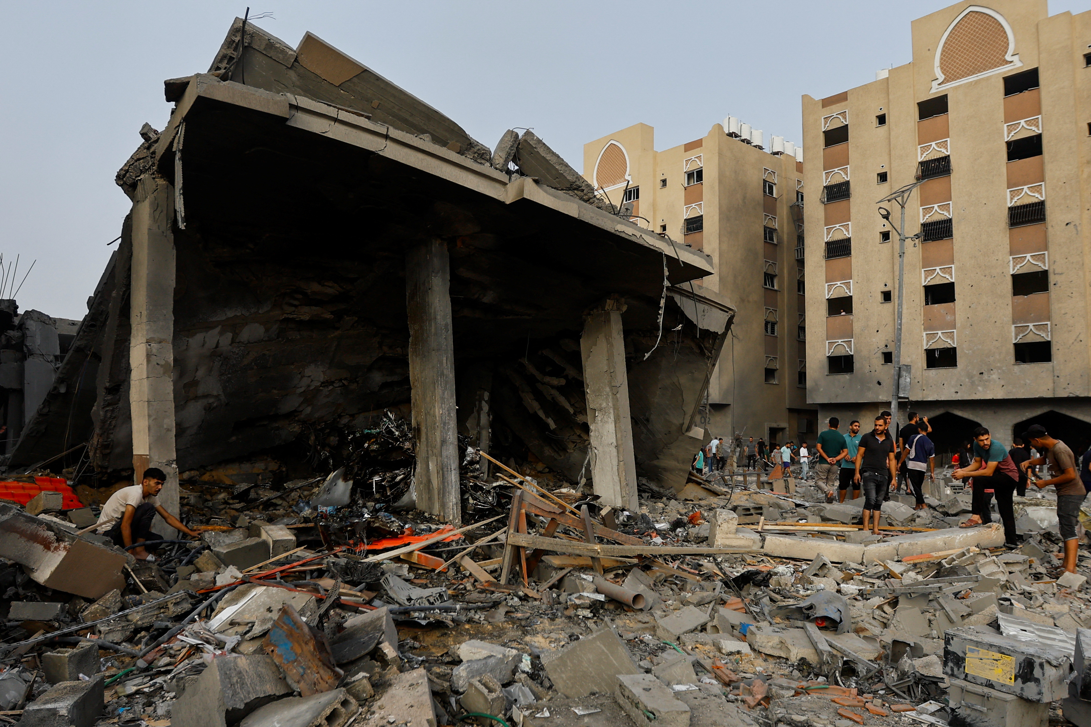 Palestinians inspect the site of Israeli strikes on a house in Khan Younis in the southern Gaza Strip, October 23, 2023. 