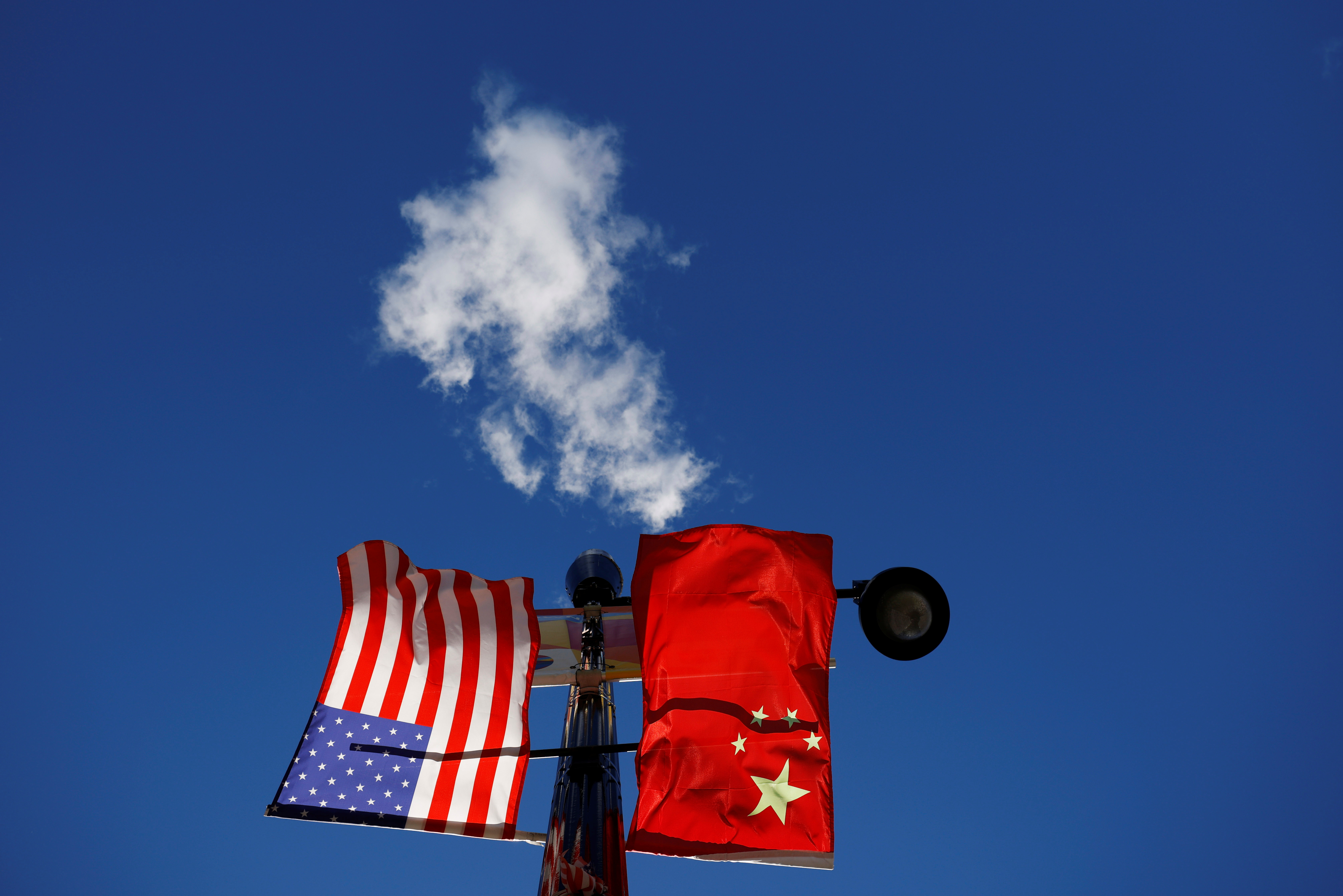 The flags of the United States and China fly from a lamppost in the Chinatown neighborhood of Boston, Massachusetts, U.S., November 1, 2021. 