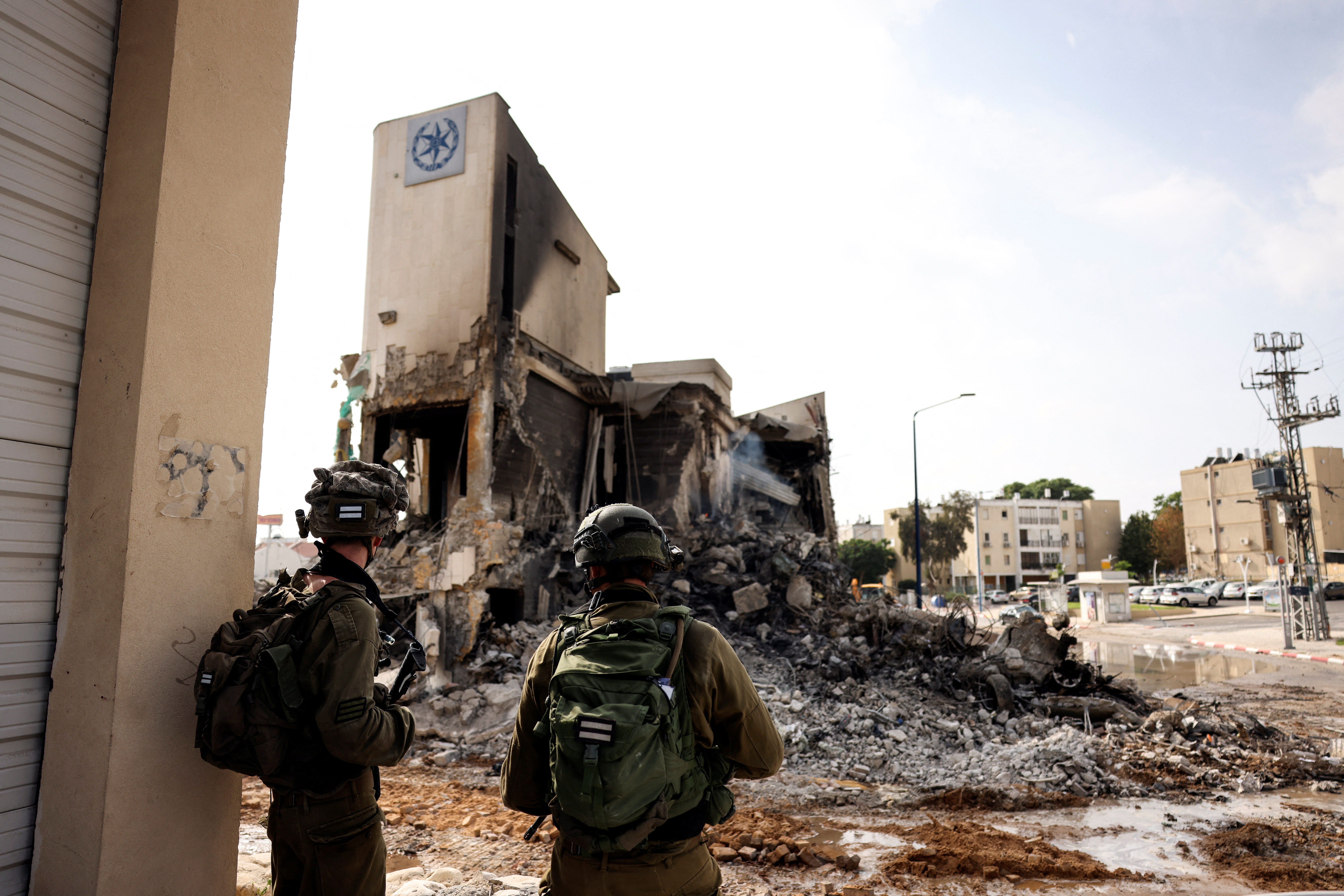Israeli soldiers look at the remains of a police station which was the site of a battle following a mass infiltration by Hamas gunmen from the Gaza Strip, in Sderot, southern Israel, Oct. 8, 2023.