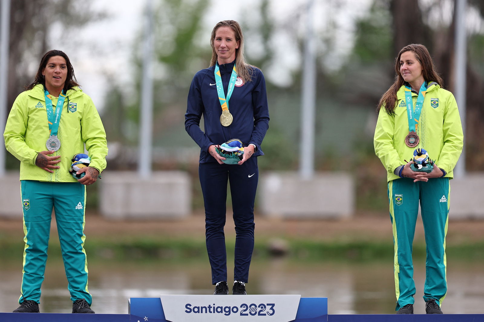 Pan-Am Games - Santiago 2023 - Open Water Swimming - Laguna Los Morros, Santiago, Chile - October 29, 2023 Gold medallist Ashley Twichell of the U.S. celebrates on the podium with silver medallist Brazil's Ana Marcela Cunha and bronze medallist Brazil's Viviane Jungblut during the women's 10km final medal ceremony.