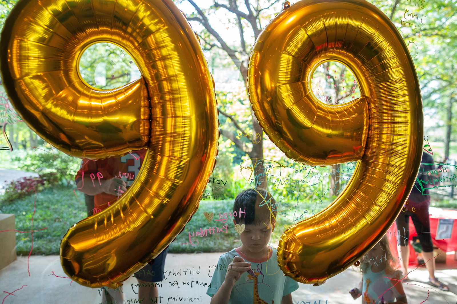 A boy writes a birthday message on a window at a public birthday party held a day before former U.S. President Jimmy Carter turns 99 years old, at the Jimmy Carter Presidential Library and Museum in Atlanta, Georgia, U.S. September 30, 2023. 