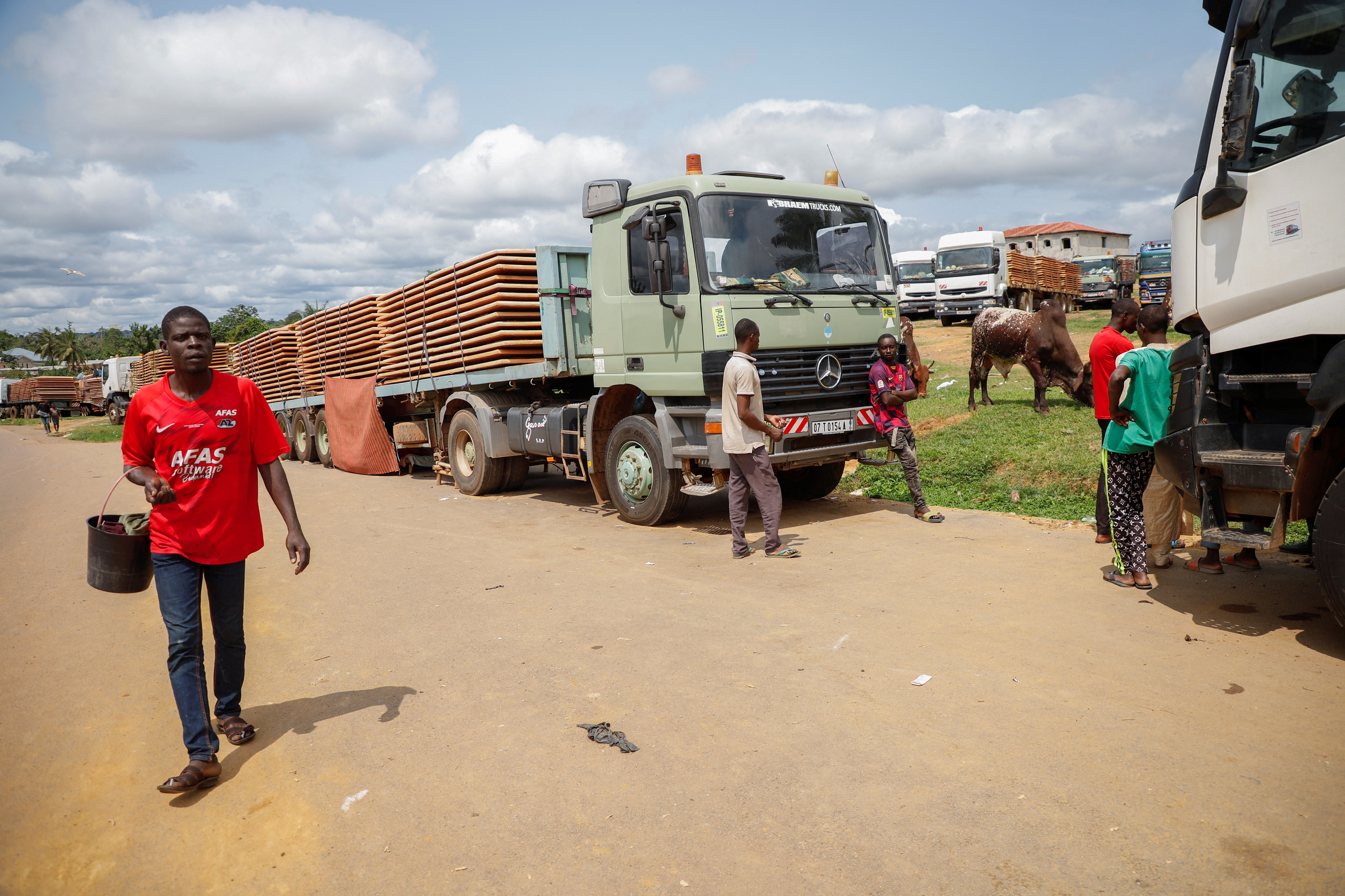 Truck drivers wait near their trucks carrying food, animals and industrial equipment because of the closure of the border after the coup in Gabon, in the border town of Kye-Ossi, Cameroon August 31, 2023. 
