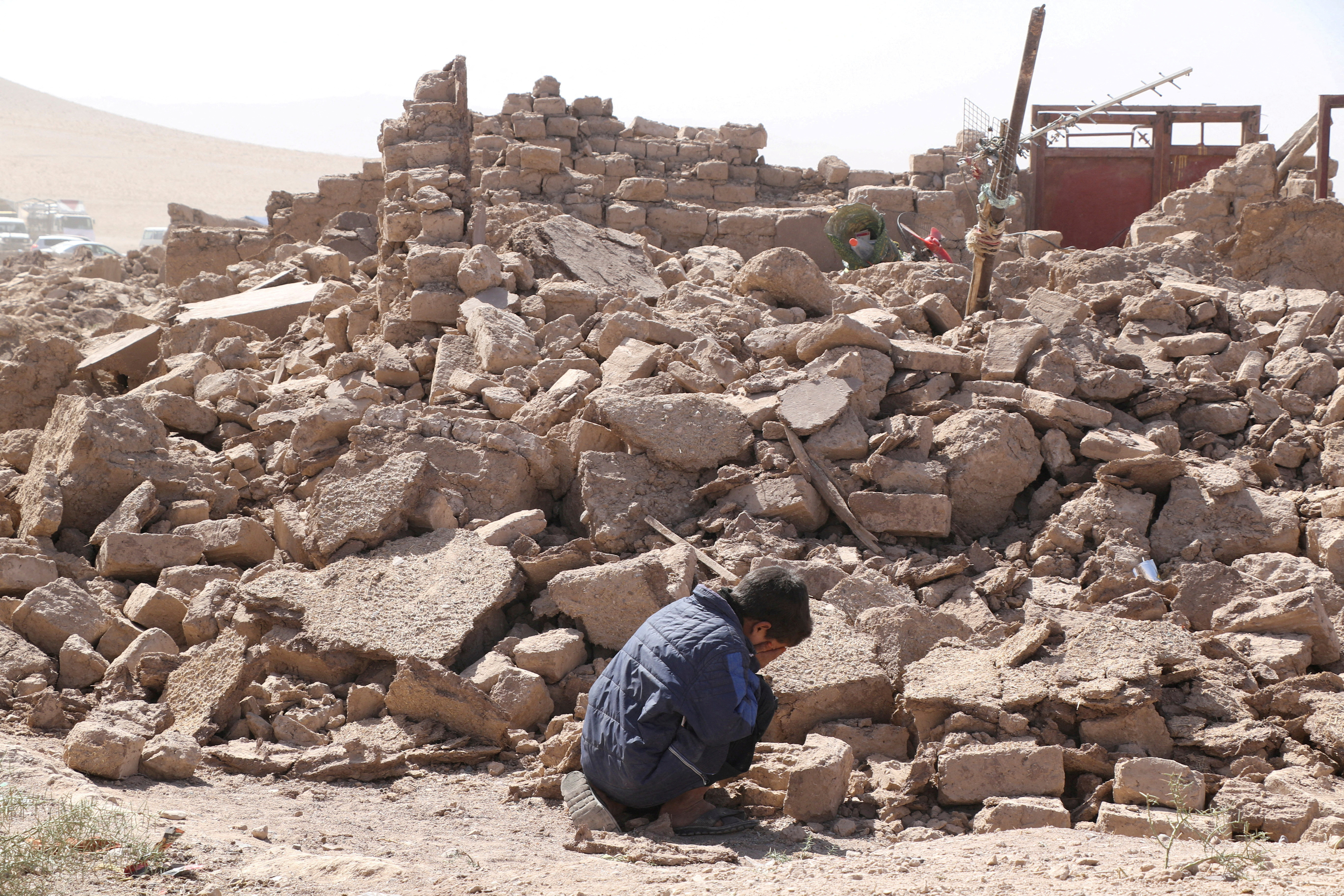 A boy cries as he sits next to debris, in the aftermath of an earthquake in the district of Zinda Jan, in Herat, Afghanistan, October 8, 2023. 