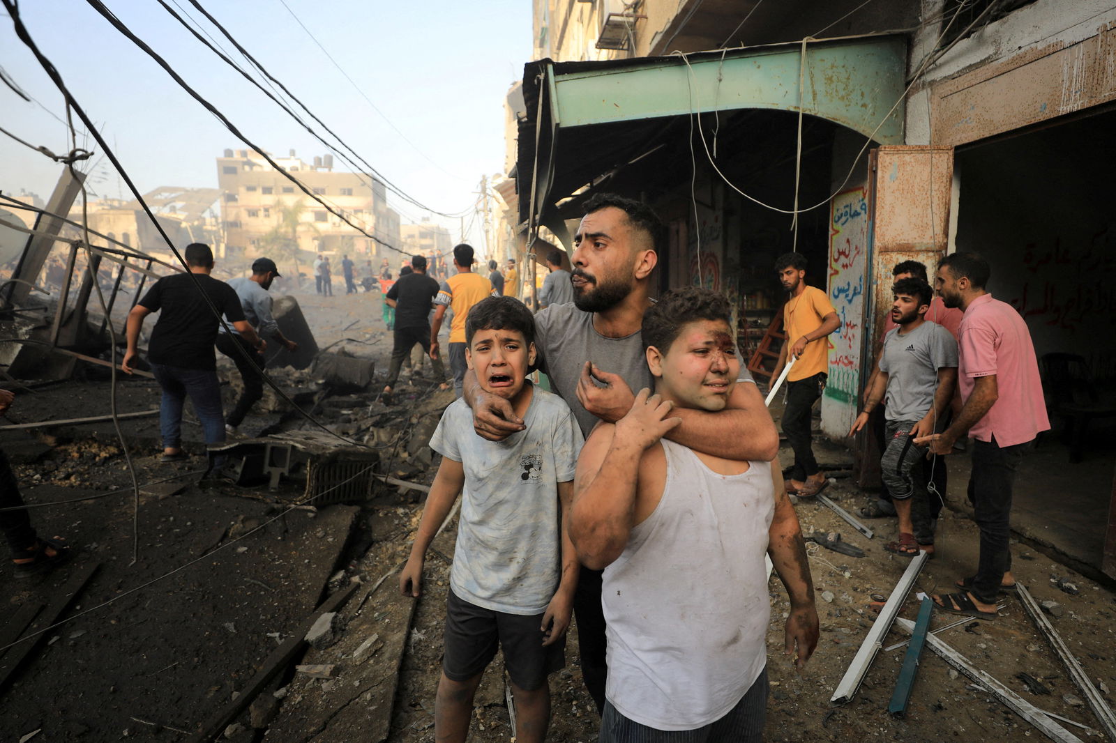 People react as Palestinians search for casualties at the site of an Israeli strike on a residential building in Gaza City, October 25, 2023. 