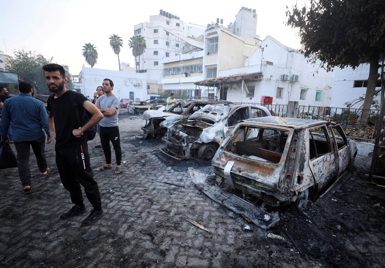 People inspect the area of Al-Ahli hospital where hundreds of Palestinians were killed in a blast that Israeli and Palestinian officials blamed on each other, and where Palestinians who fled their homes were sheltering amid the ongoing conflict with Israel, in Gaza City, October 18, 2023. 