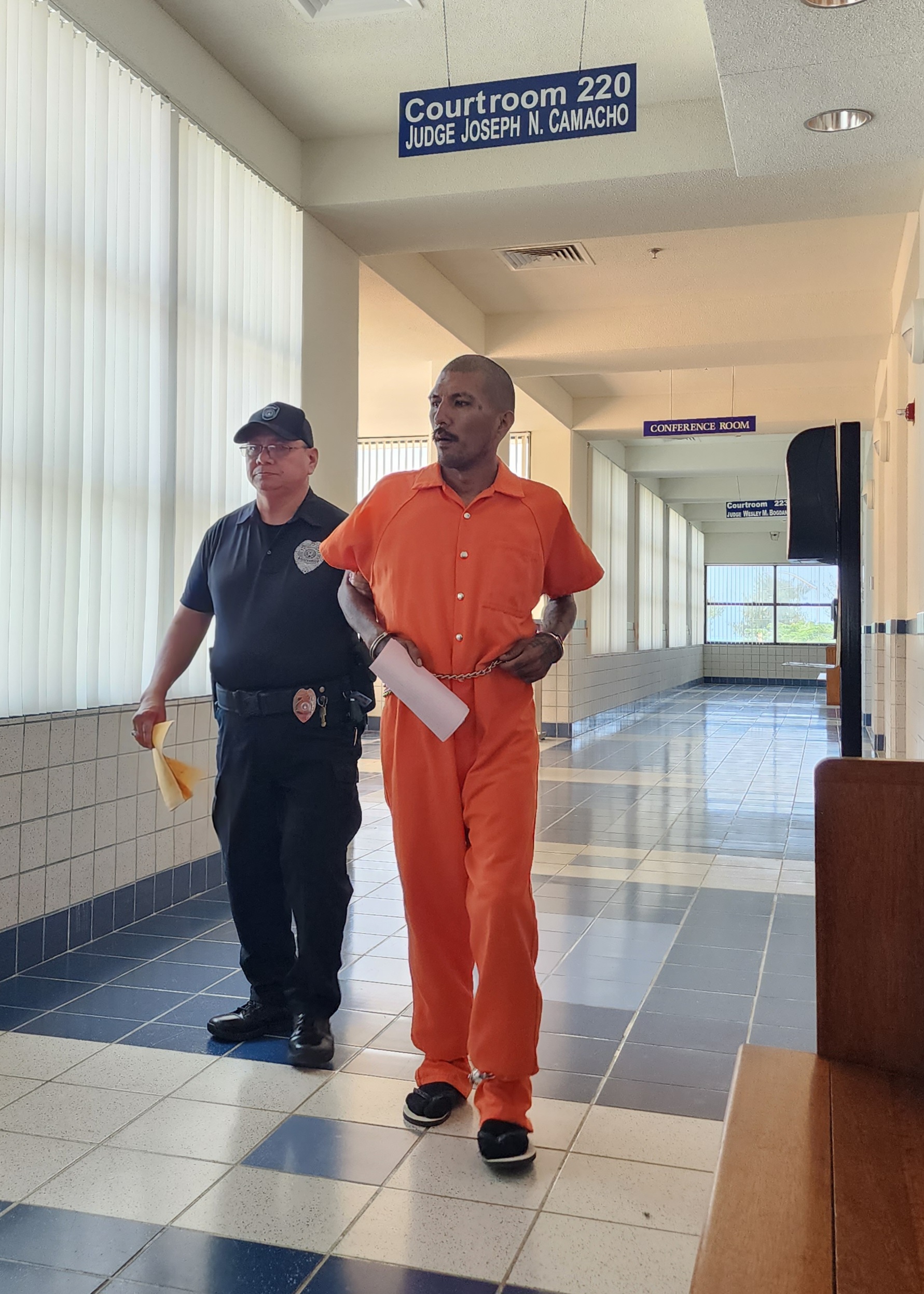 Michael Jesse Aguon Manalo is escorted by a Corrections officer after a bail hearing on Monday morning.     